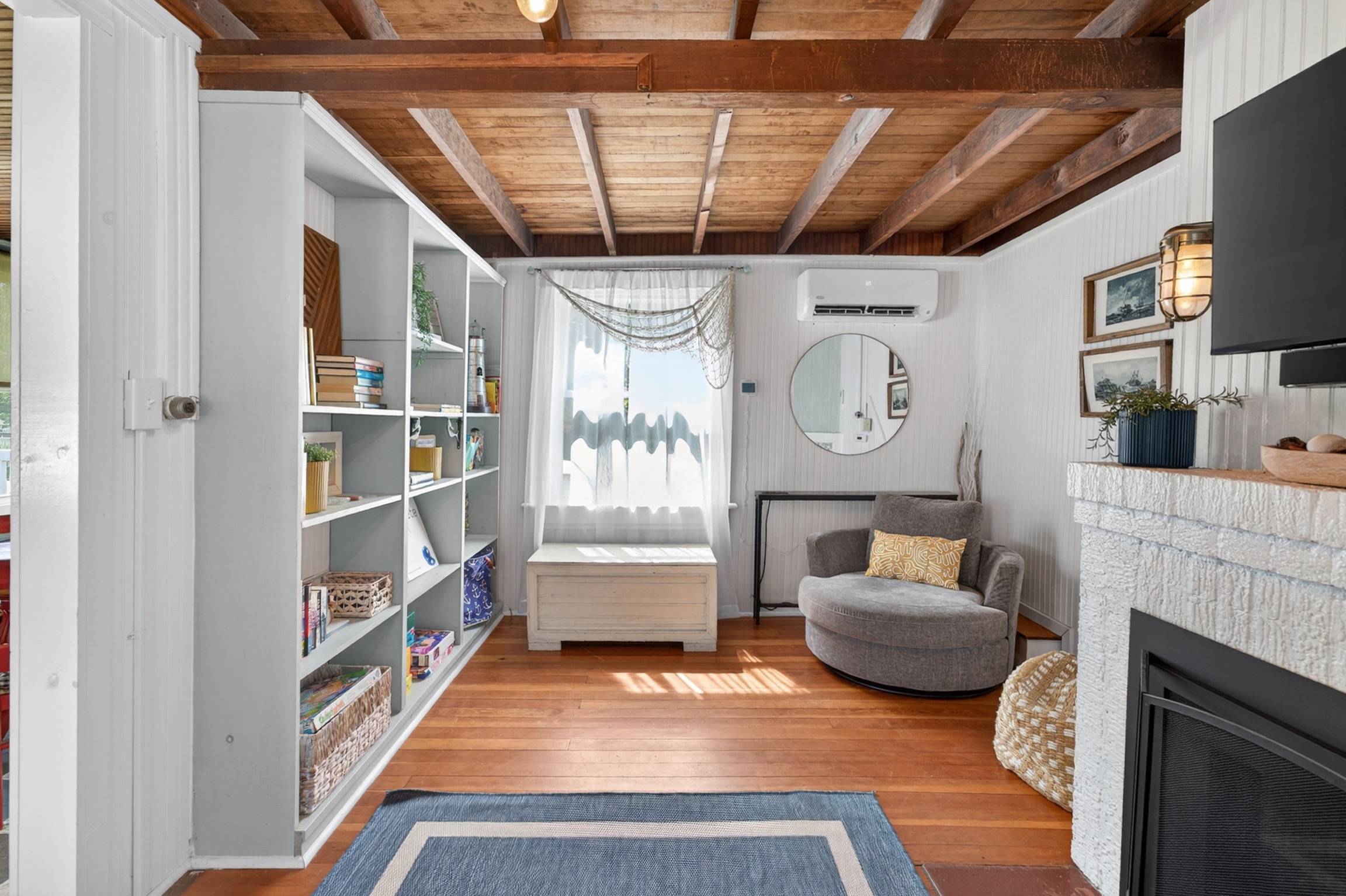 Comfortable living room featuring an abundance of games, books, cozy seating, and a smart TV for relaxing nights in.