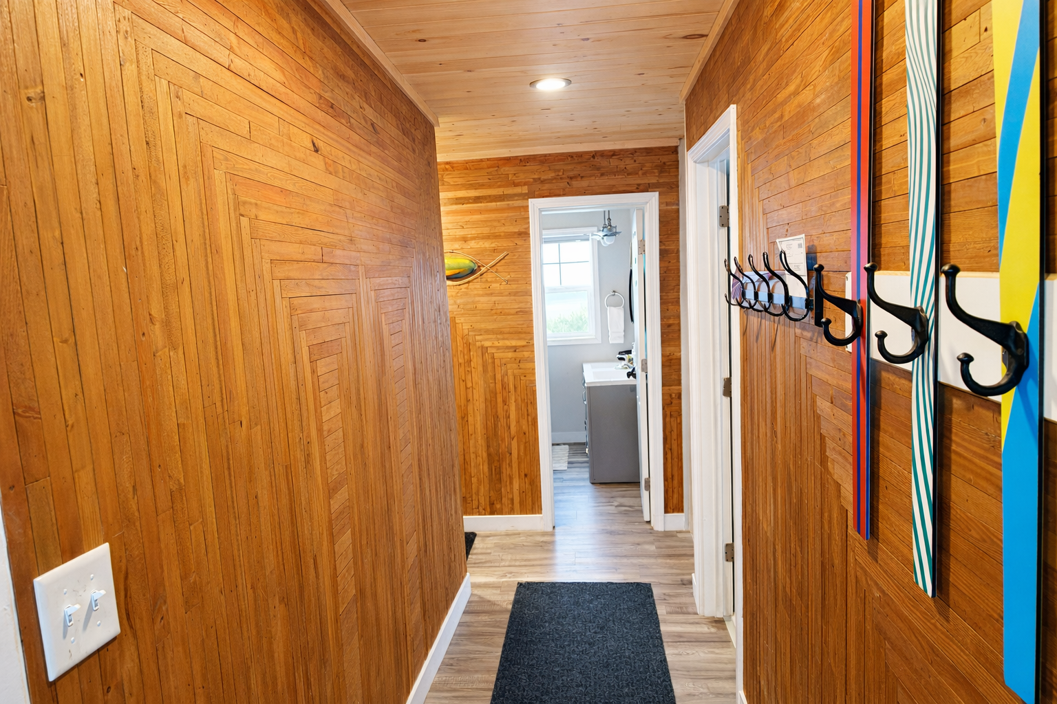 Step into the entryway and you’ll catch a unique blend of charm and function. A row of quirky hooks some crafted from skis welcomes you to hang up your gear. Straight ahead, you’ll get a glimpse of the bathroom window offering a peek at Lake Superior. 
