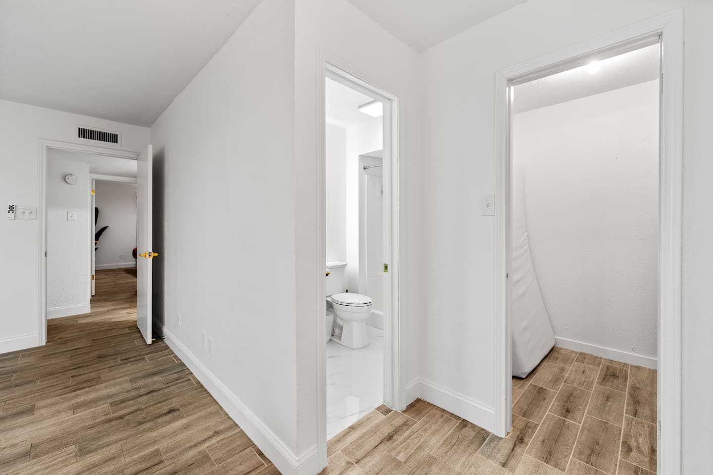 Bright, inviting hallway with sleek flooring and soft lighting connecting bedrooms and living areas.