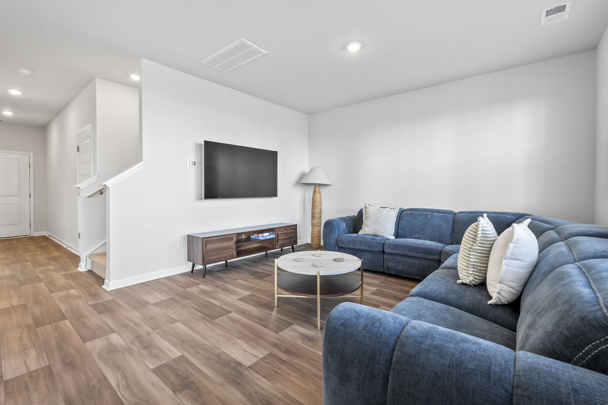 Living room with large wrap around couch and Roku Smart TV