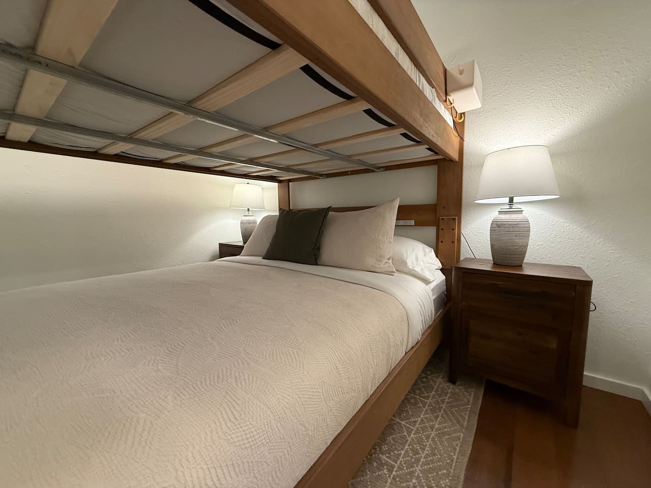 Nightstands with a lamp and electrical outlets and USB outlets on either side of the bed. 