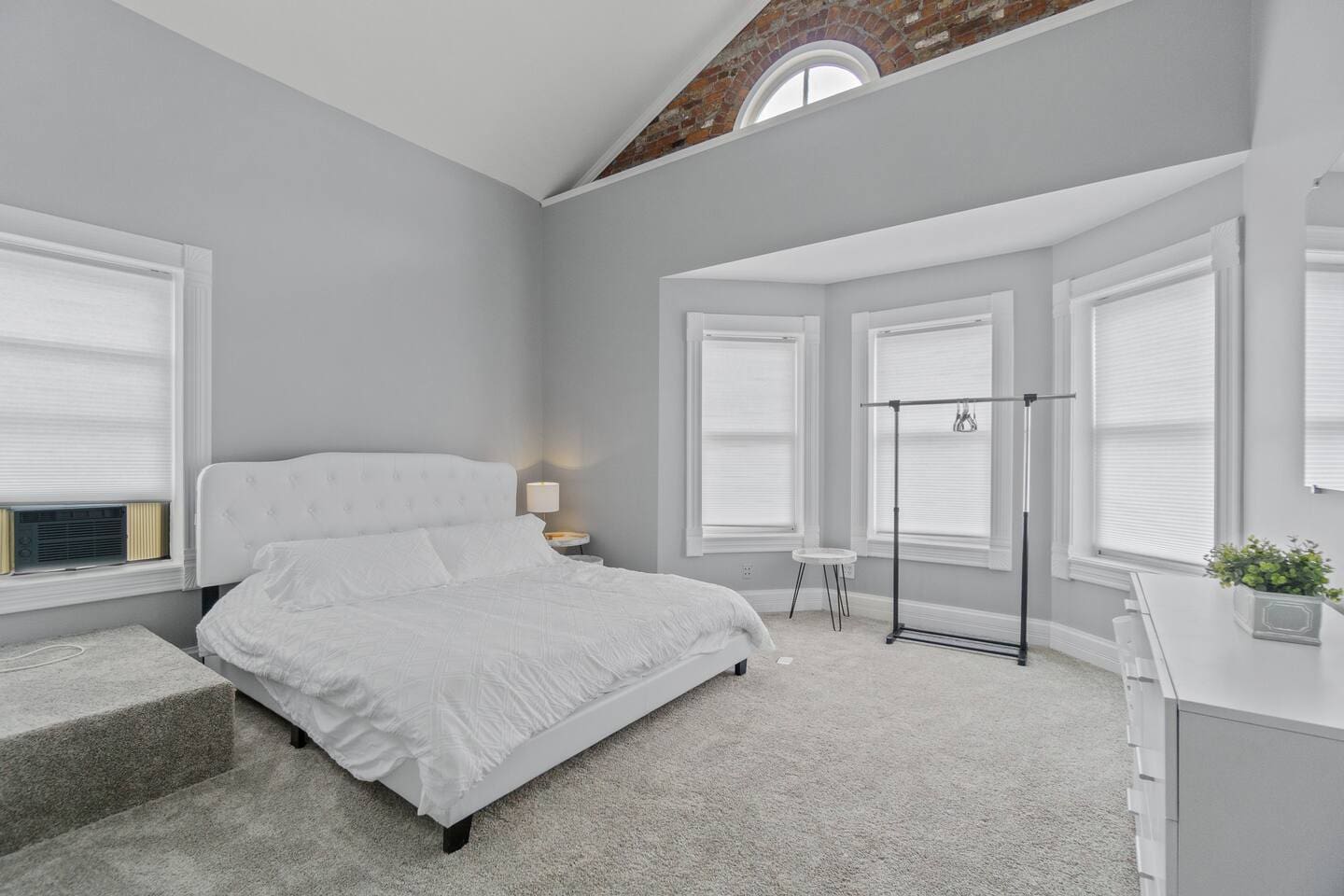 Spacious and neat king-sized bedroom with a clean white interior, offering a serene and luxurious retreat.
