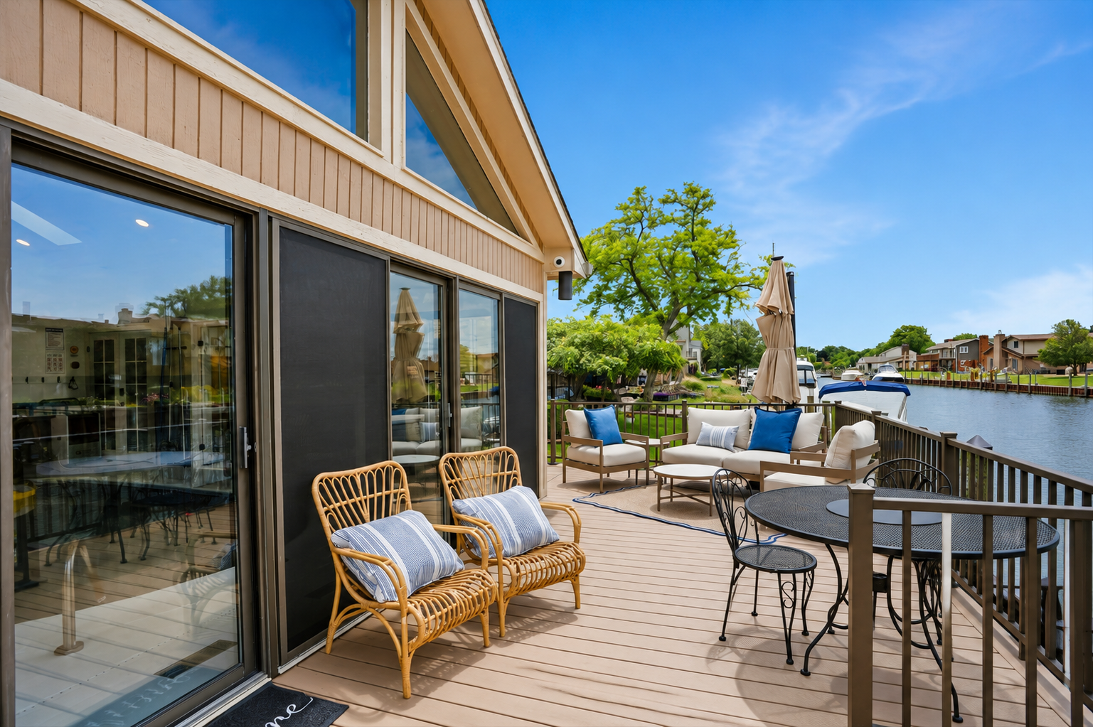 Spacious waterfront deck with lounge seating and dining area overlooking the canal. Bright, open outdoor space perfect for relaxing, entertaining, and enjoying peaceful water views.