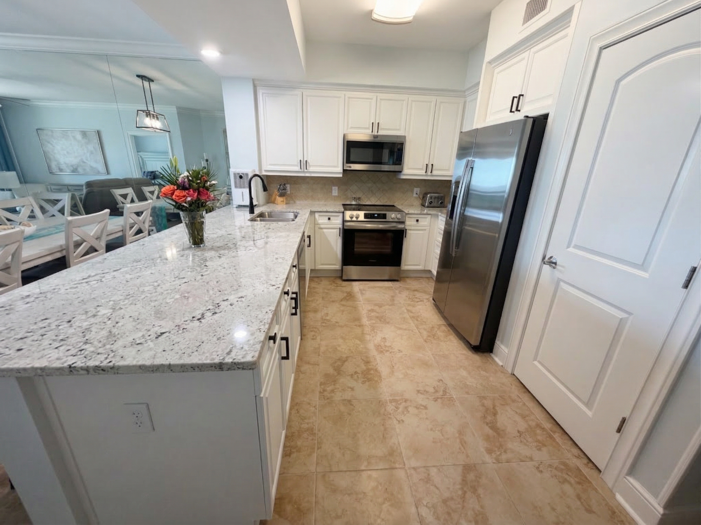 Spacious kitchen with granite countertops, stainless appliances, and bar seating—perfect for coffee mornings or family meals together.