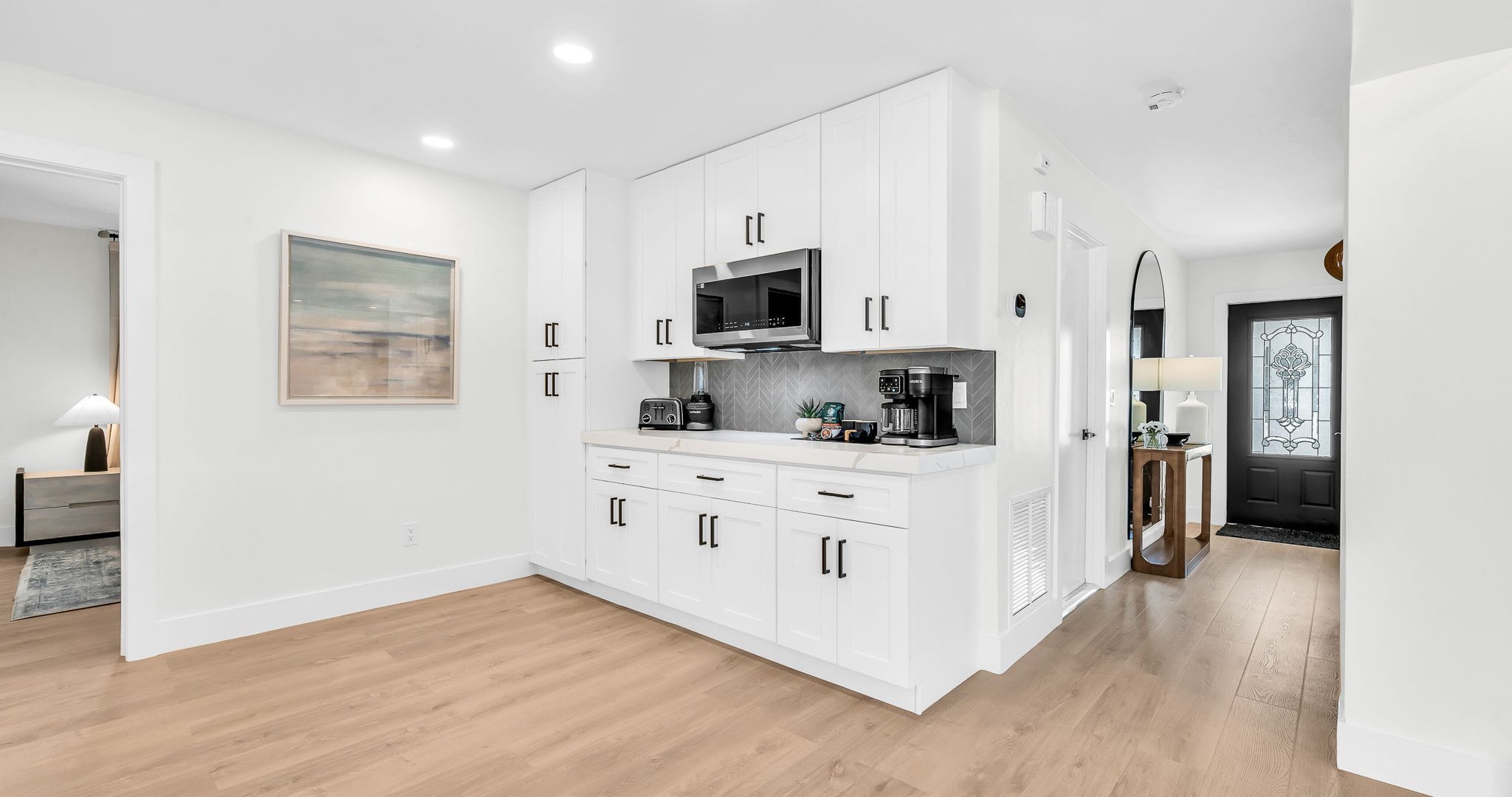 This fully renovated kitchen is the heart of the home, featuring a stunning quartz waterfall island, sleek white cabinetry, and brand-new stainless steel appliances. Perfect for cooking, entertaining, or simply gathering with loved ones