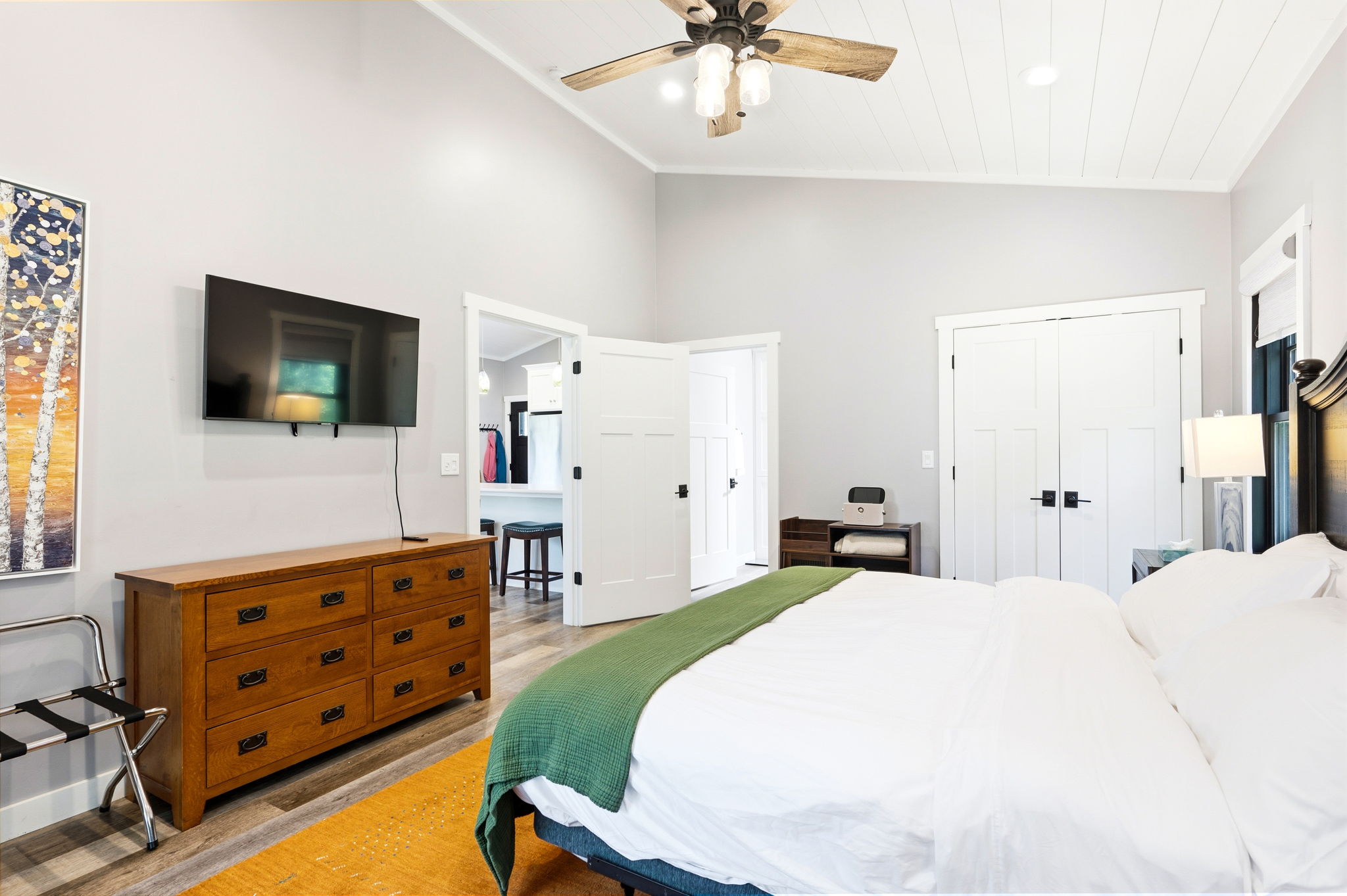 Enjoy a restful night's sleep in the primary bedroom, appointed with a plush king bed, mounted smart-TV, and a private en suite bath just steps away.