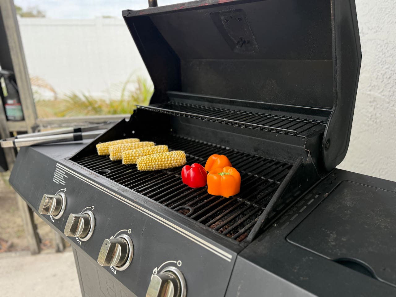 Gas grill sitting on the back patio near the pool area ready to grill an amazing lunch