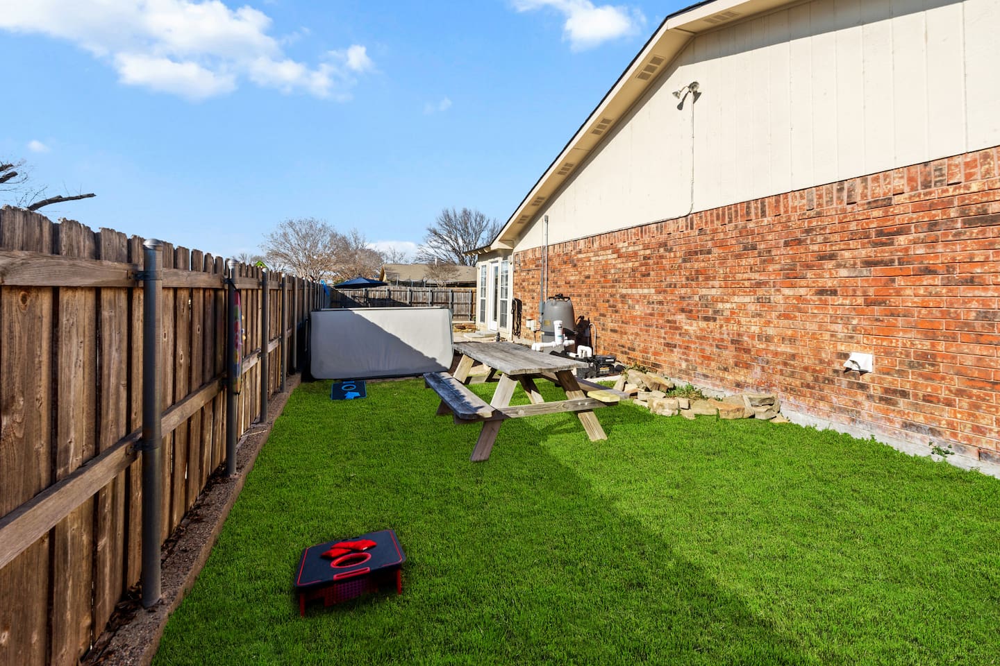 Grassy backyard fully enclosed for privacy and outdoor activities.