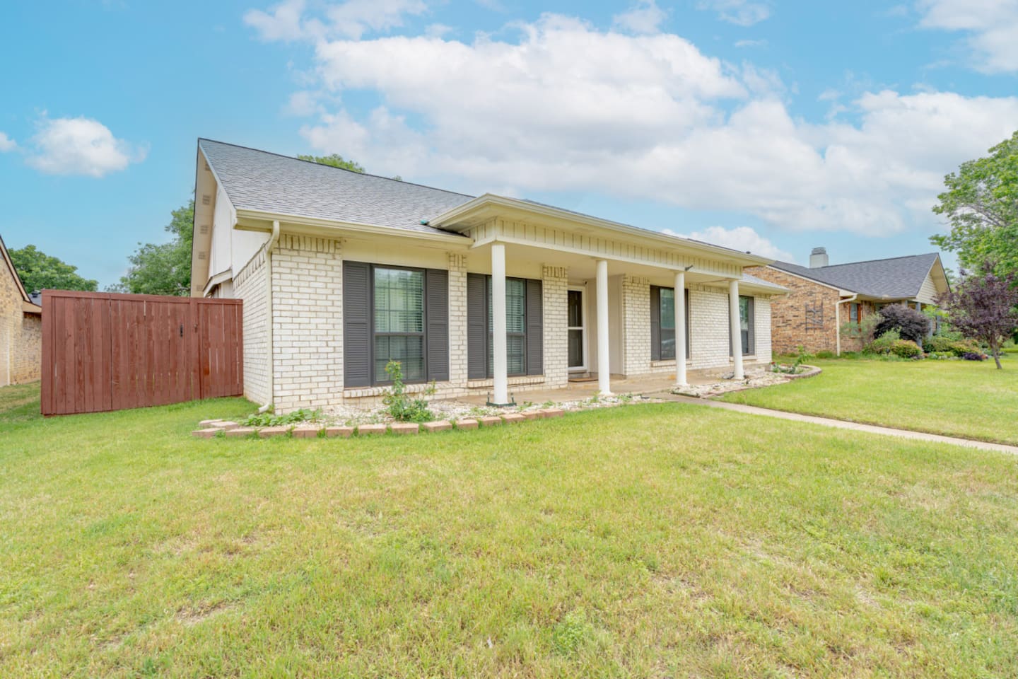 Welcoming curb appeal with manicured lawn and covered entry.