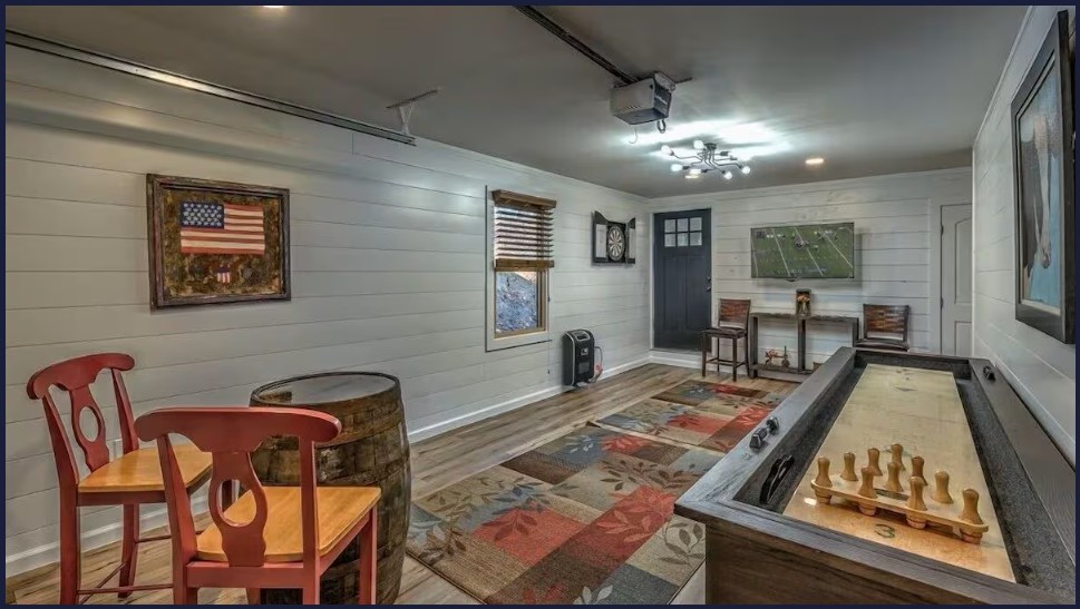 Game room with shuffleboard, foosball, darts, TV, and cozy cabin charm.