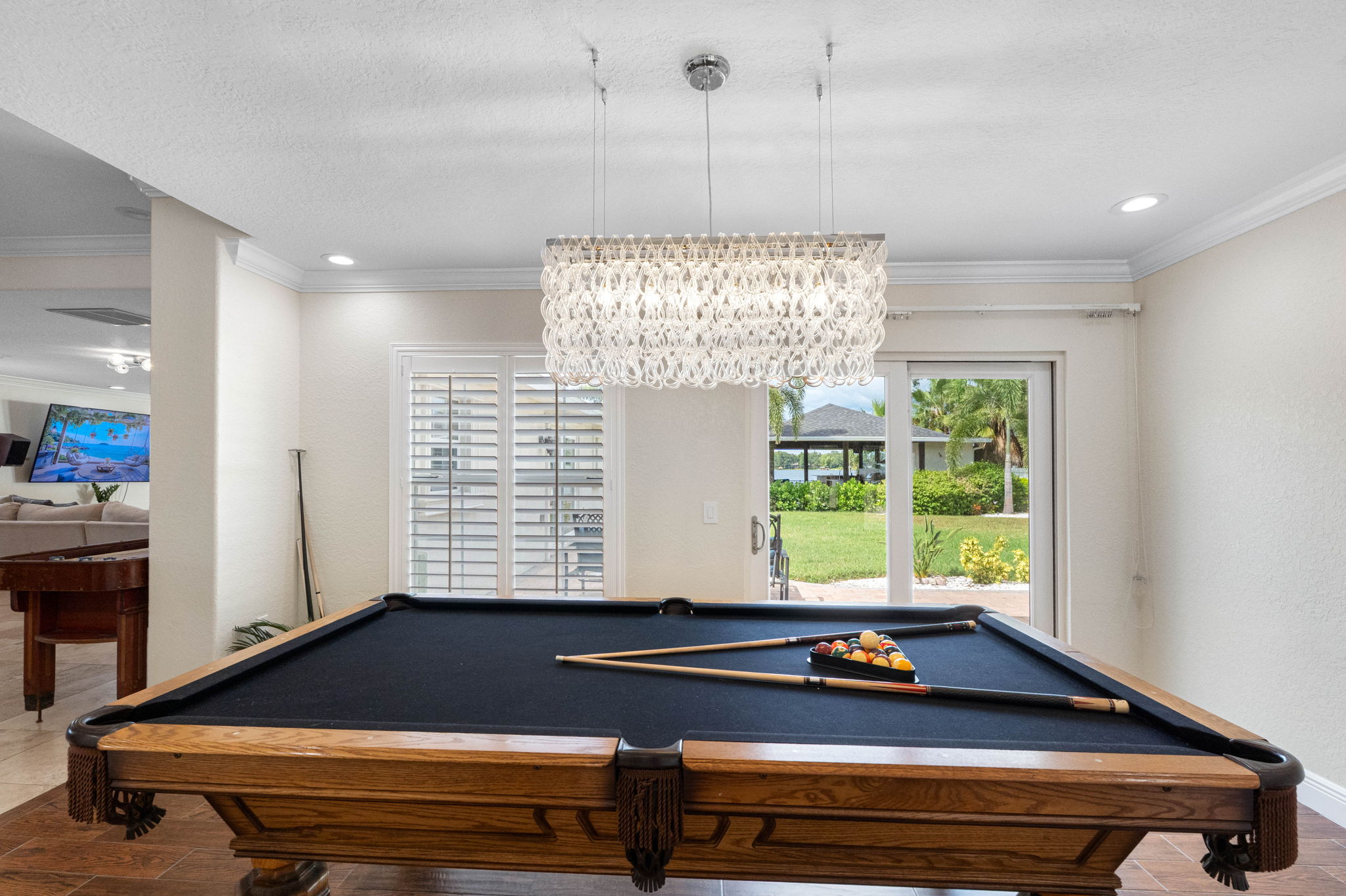 With its crystal light fixture, rich wood accents, and waterfront access, this game room blends luxury and leisure. The pool table takes center stage for friendly competition.