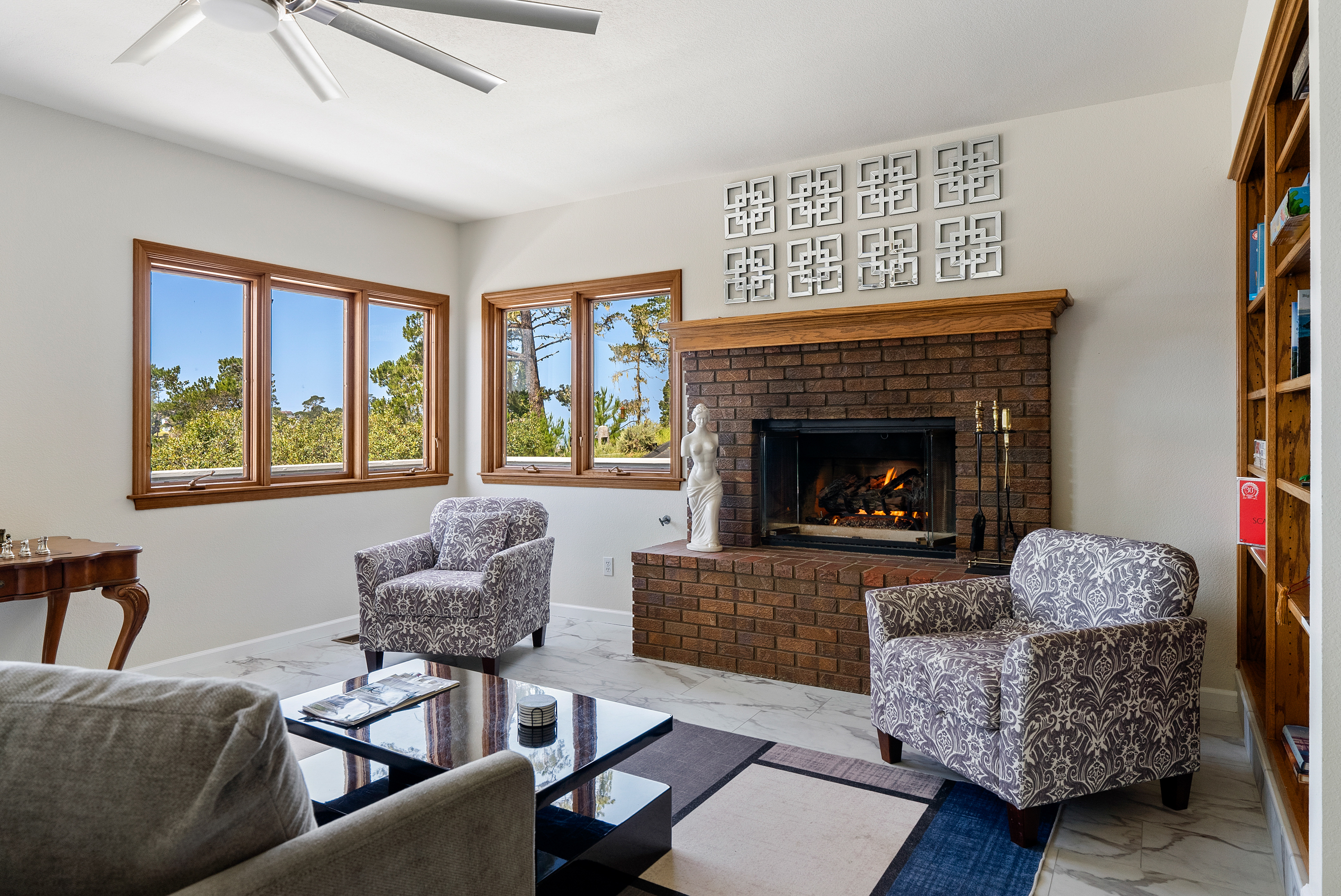 Cozy up by the fire in this inviting, sun-filled living room.