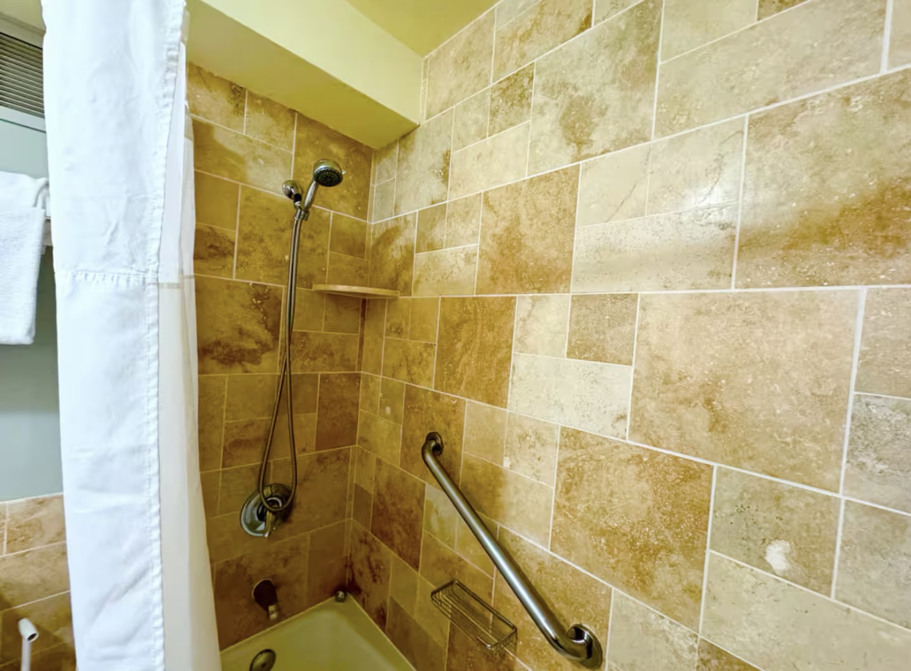 Roomy travertine shower with bathtub