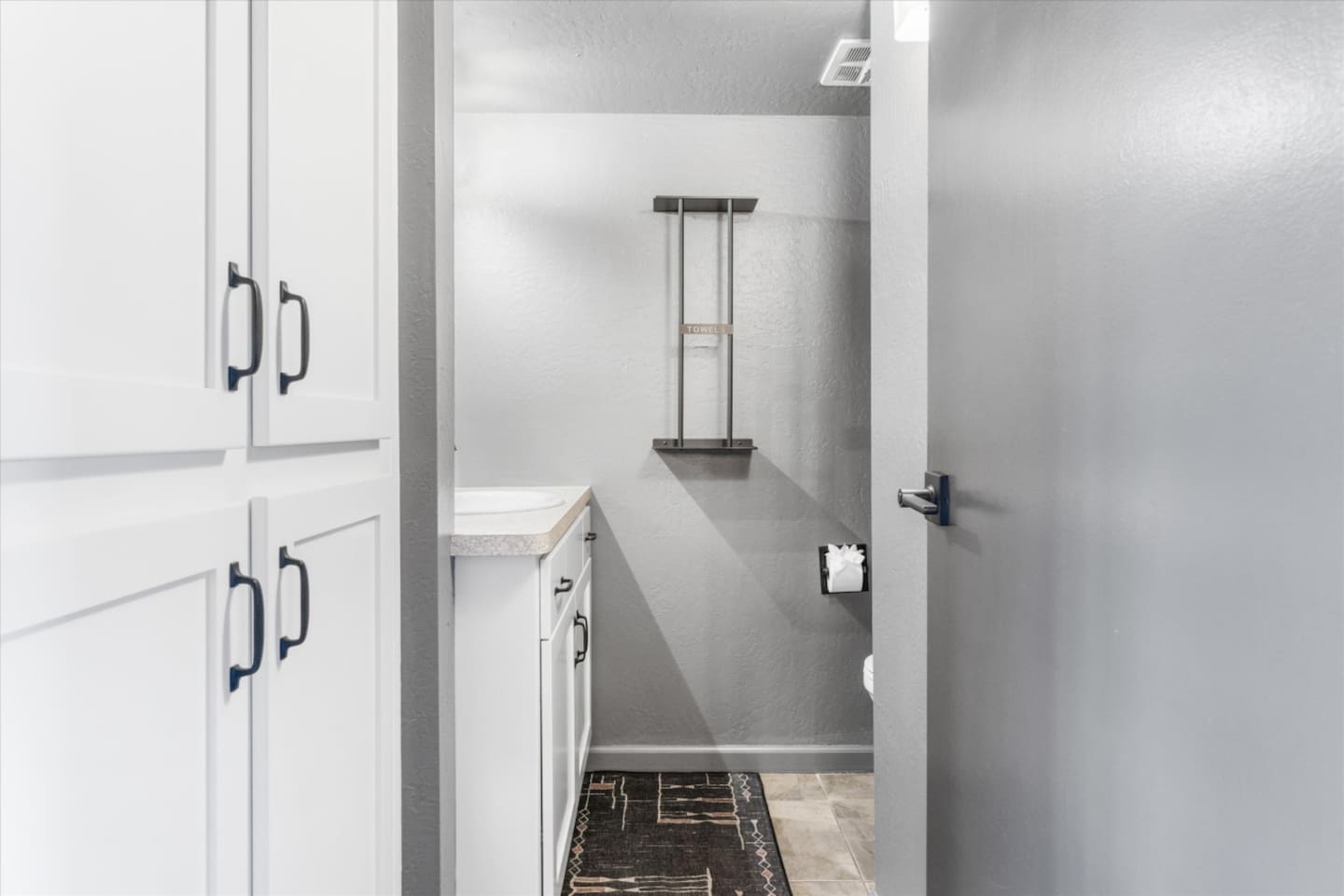 Half bathroom with a clean vanity area, and cabinet storage