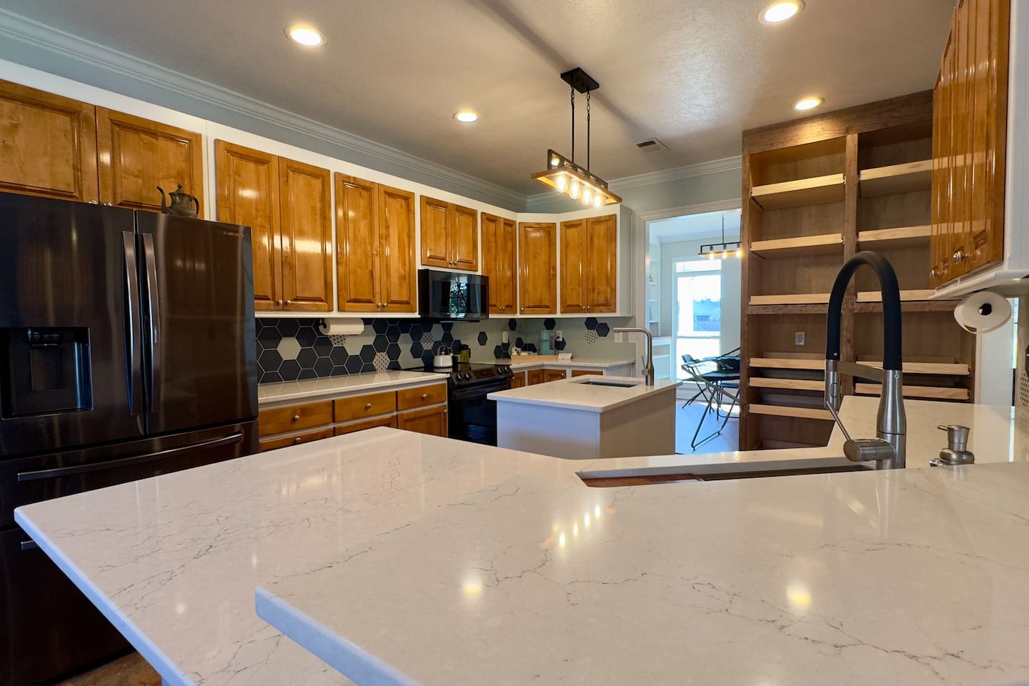 Double sink with high-arc faucet, built-in microwave, and ample shelving make cooking effortless