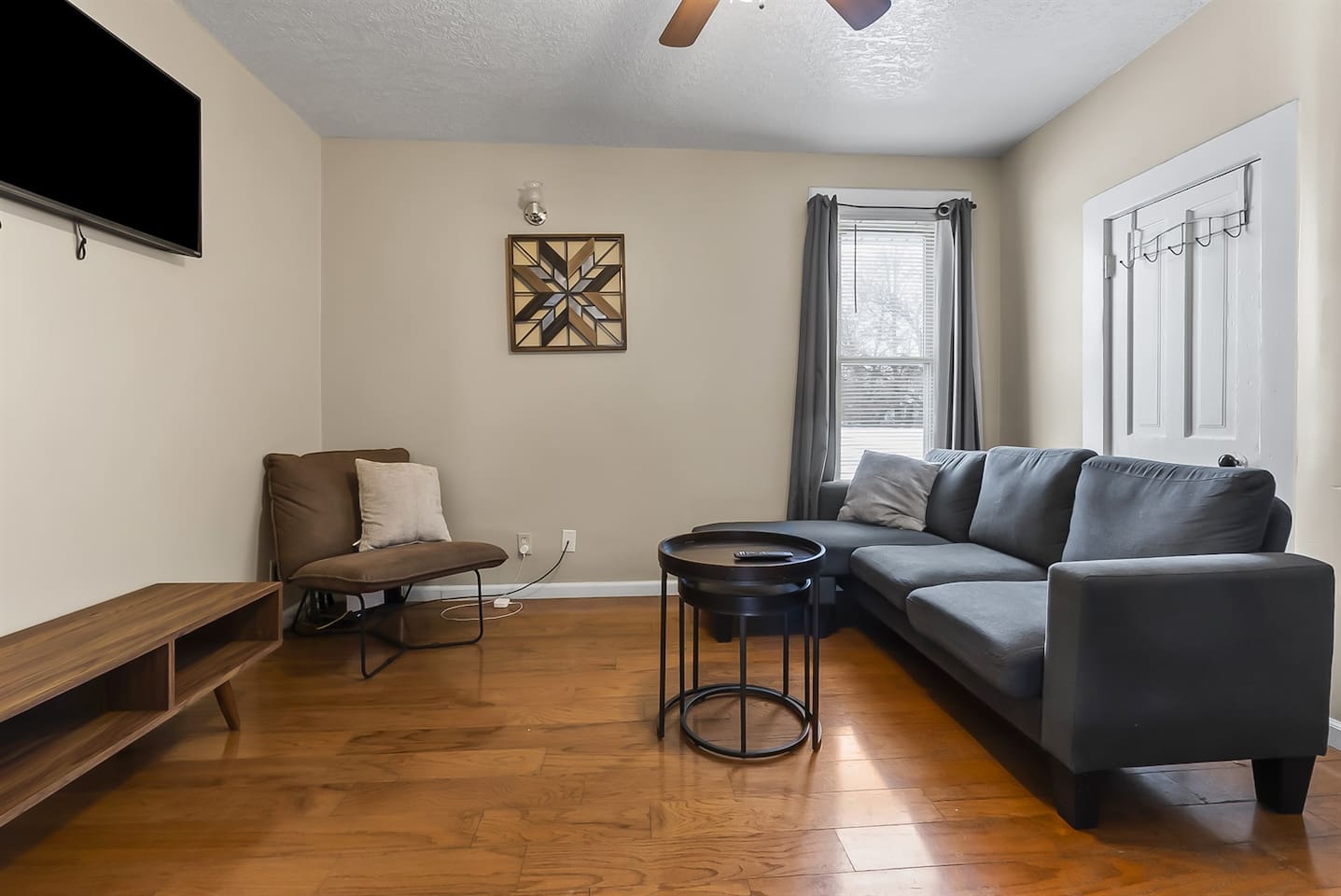 Inviting living room featuring a comfortable couch, sleek mini center table, and a flat-screen TV for your relaxation.