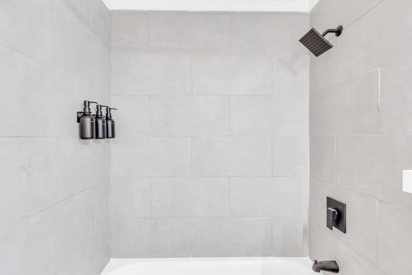 Bathroom with walk-in shower and sleek tile finish and luxe bath products.