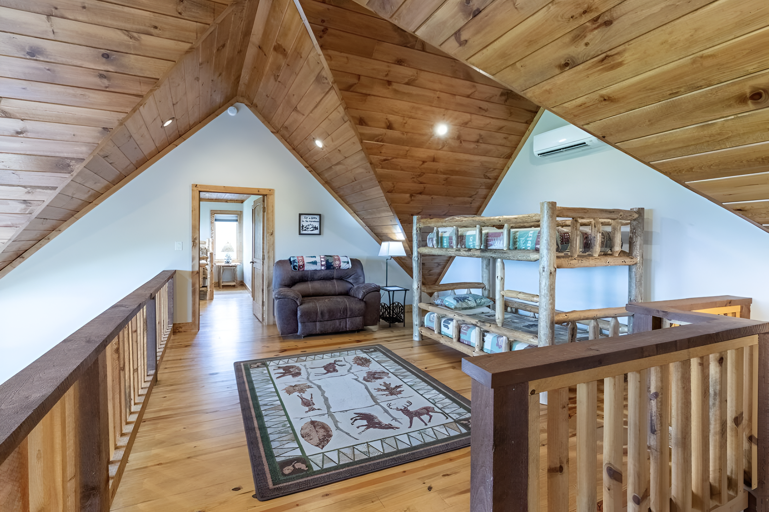 The large loft area has a bunk bed and receives lots of natural light, overlooking the living room.