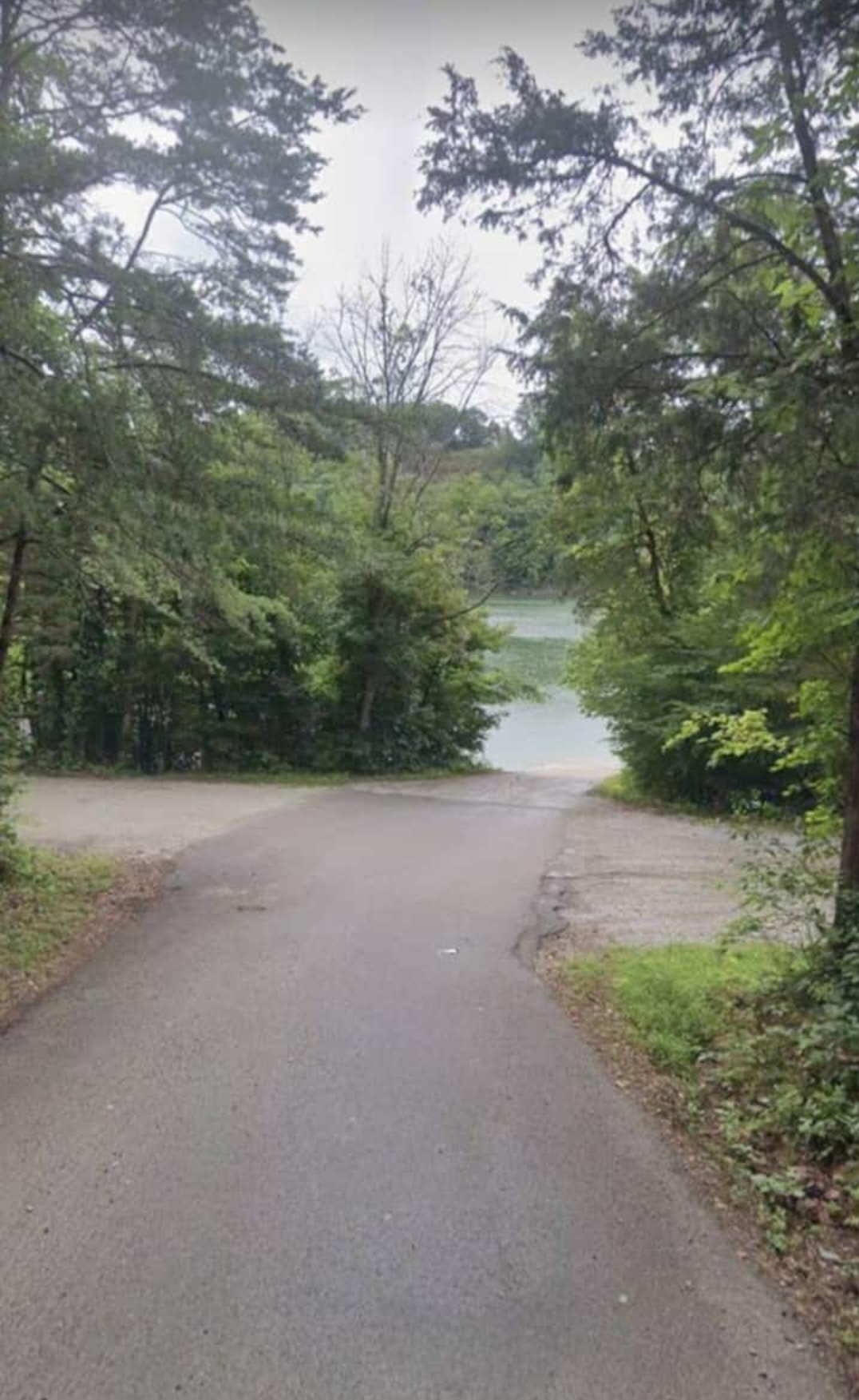 The road from the neighborhood leads past serene surroundings to the ramp and parking areas for lake access.