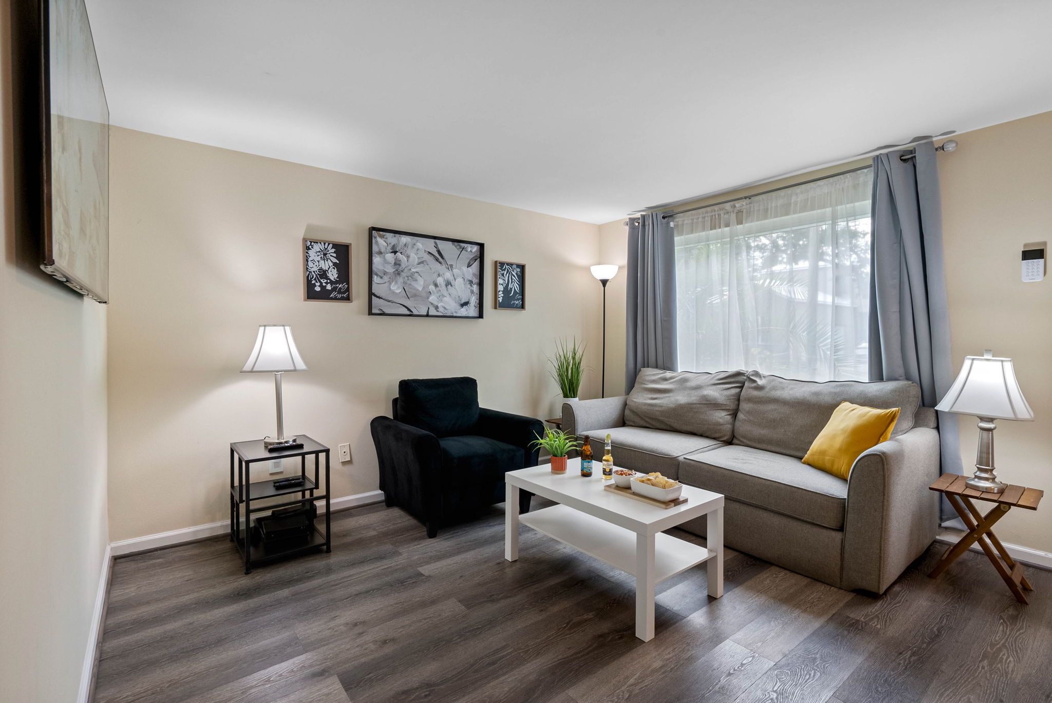 This thoughtfully decorated room features a neutral-toned sofa accented with vibrant yellow throw pillows