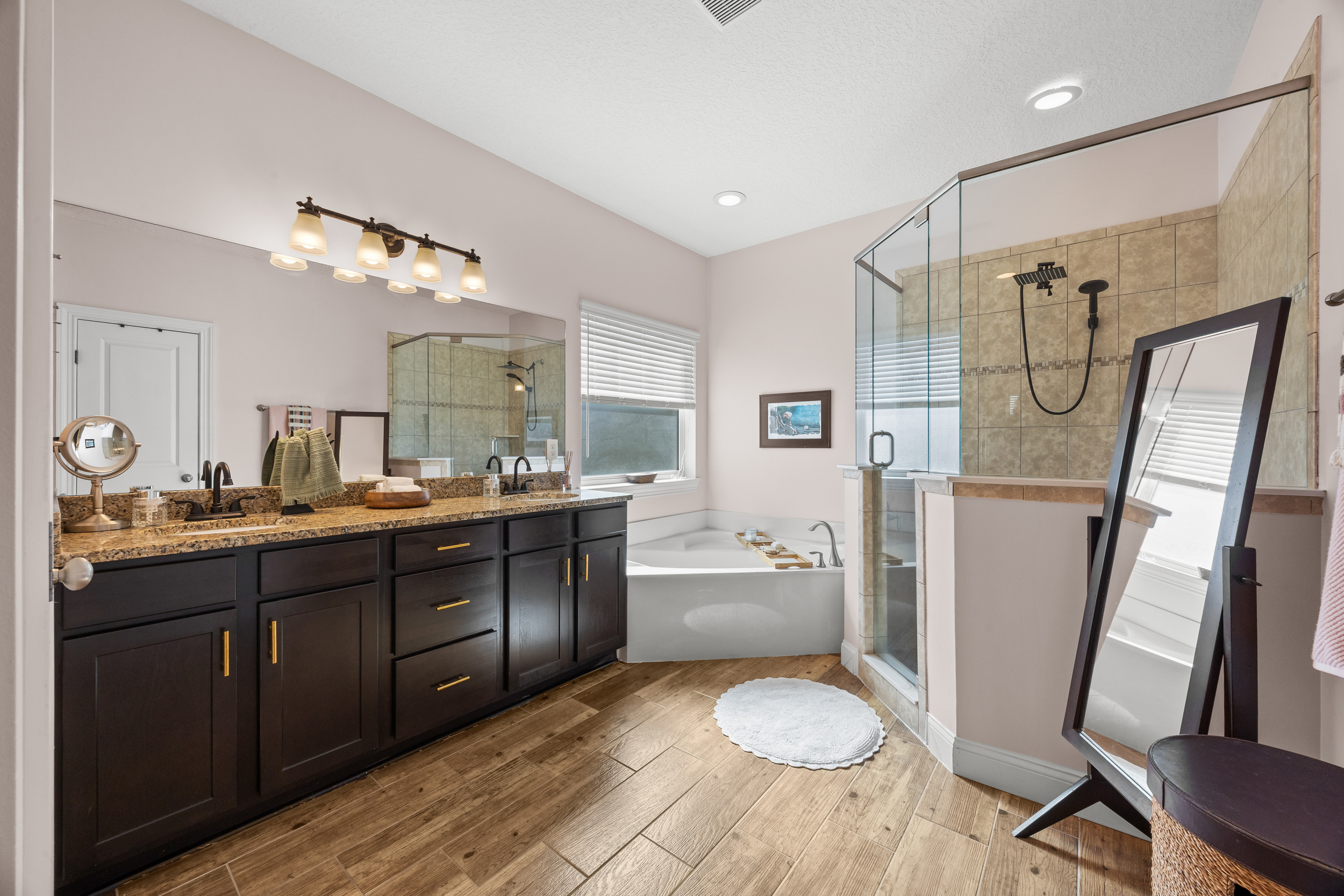 Relaxing bathroom with rainfall shower and soaking tub setup in Jacksonville Beach vacation rental.
