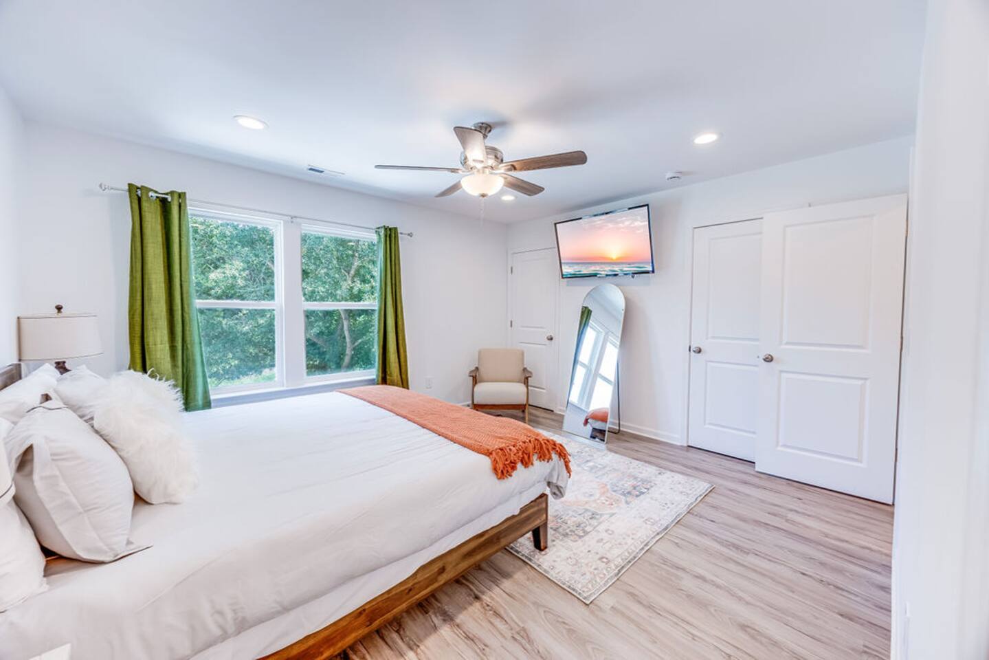 Enjoy the spacious master bedroom with large open windows, two closets for ample storage, and a TV for added convenience and relaxation.