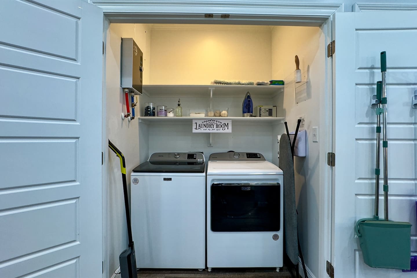 Convenient laundry nook with washer, dryer, and organized storage shelves.