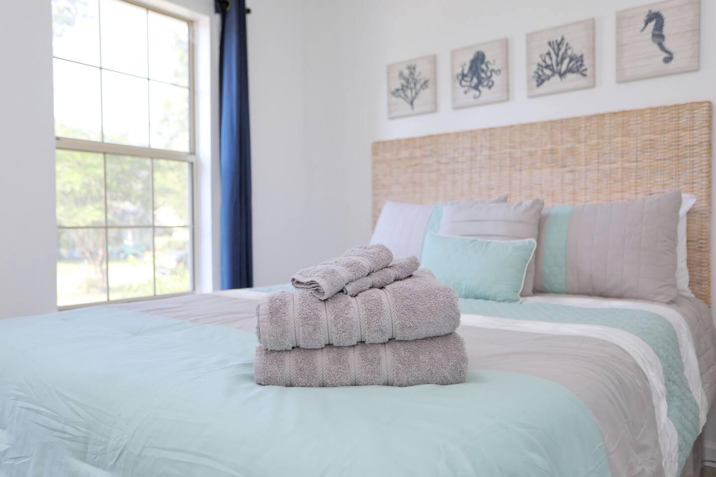 Bright and inviting, the second bedroom features a cozy queen bed, a convenient desk, and large windows that fill the space with natural sunlight.