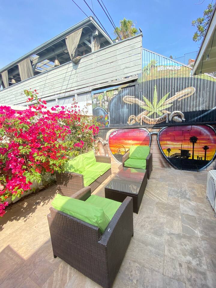 Private outdoor lounge surrounded by vibrant flowers and custom mural art.