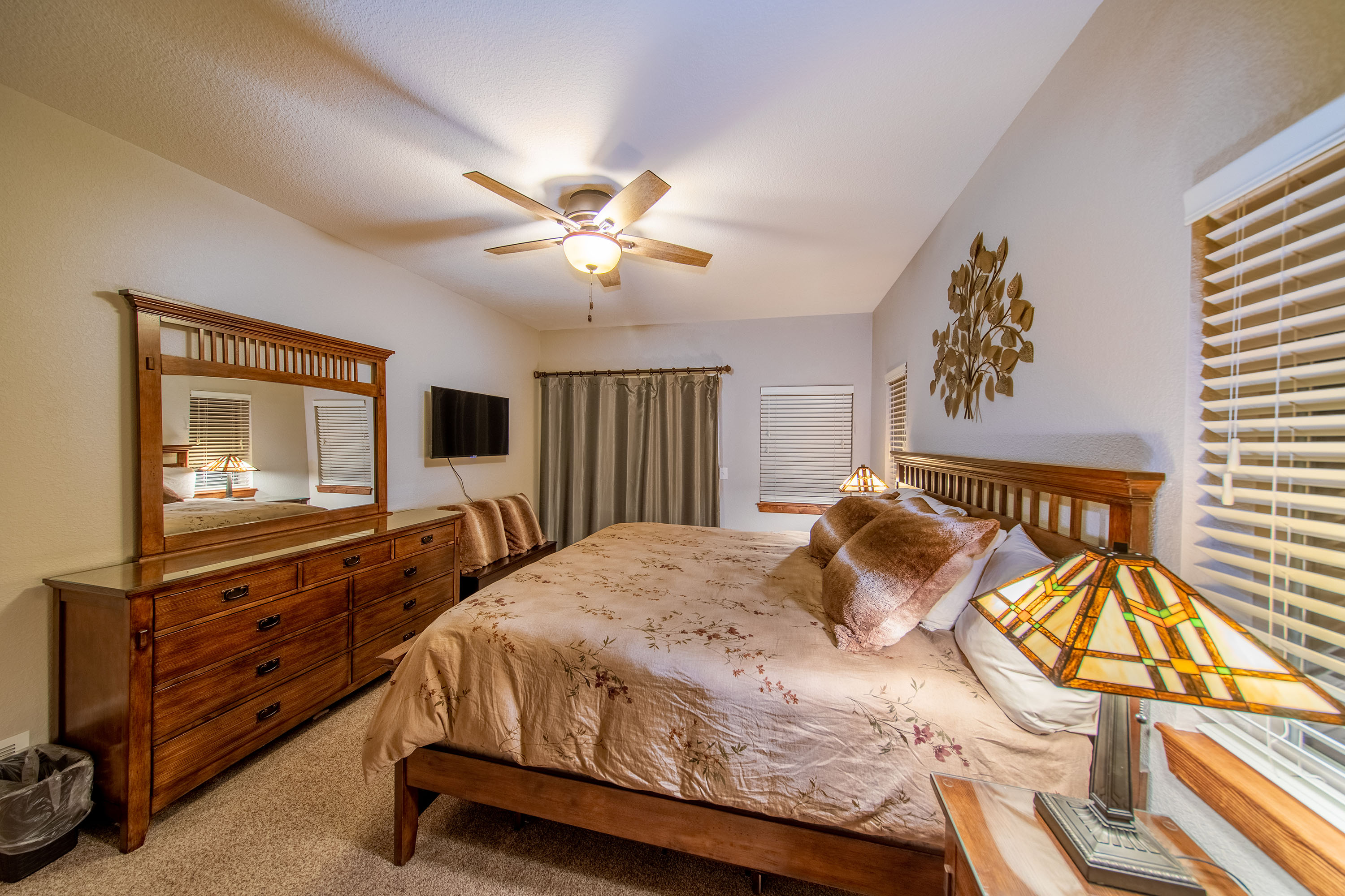 Relax in the main level bedroom featuring a comfortable king bed, stylish furniture, and a Roku Smart TV.