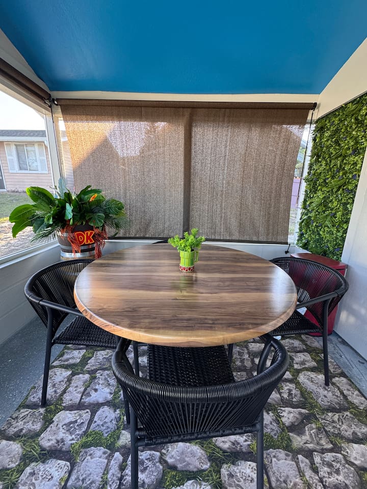 Cozy outdoor Donkey Kong inspired dining set on the patio of Mario's Mini Mansion, Clermont, FL! Round table with comfortable woven chairs offers a relaxed spot to eat, chat, or play games.