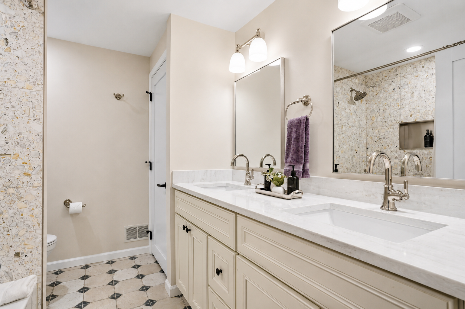 Bright, modern spa-style bathroom with dual quartz vanities, polished finishes, and a walk-in shower. Clean, spacious design with soft lighting creates a fresh, hotel-like feel.