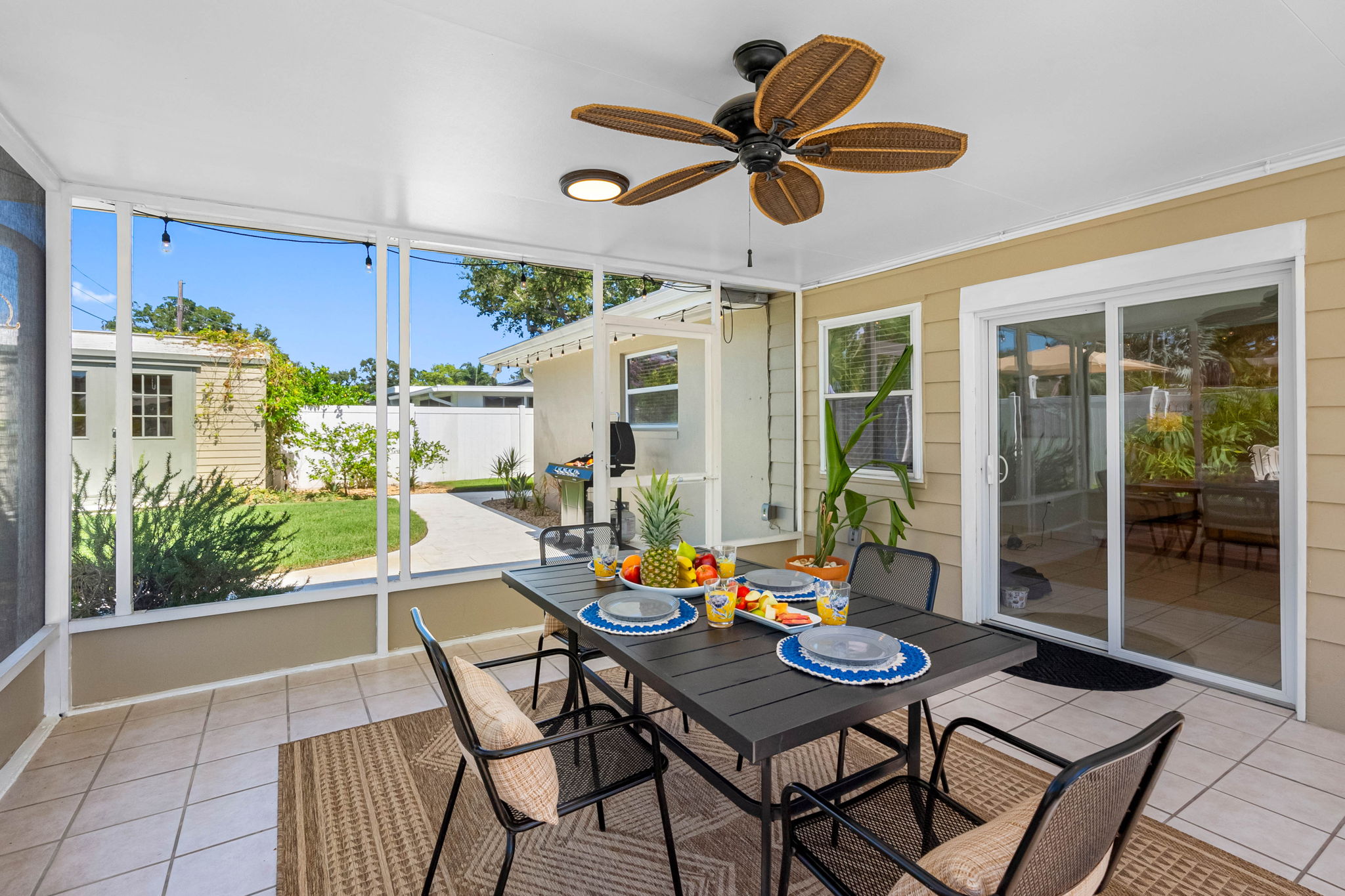 This charming patio offers a breezy, shaded space for outdoor meals or cocktails with friends. With a view of the pool and tropical landscaping, it's ideal for relaxing in comfort and style.