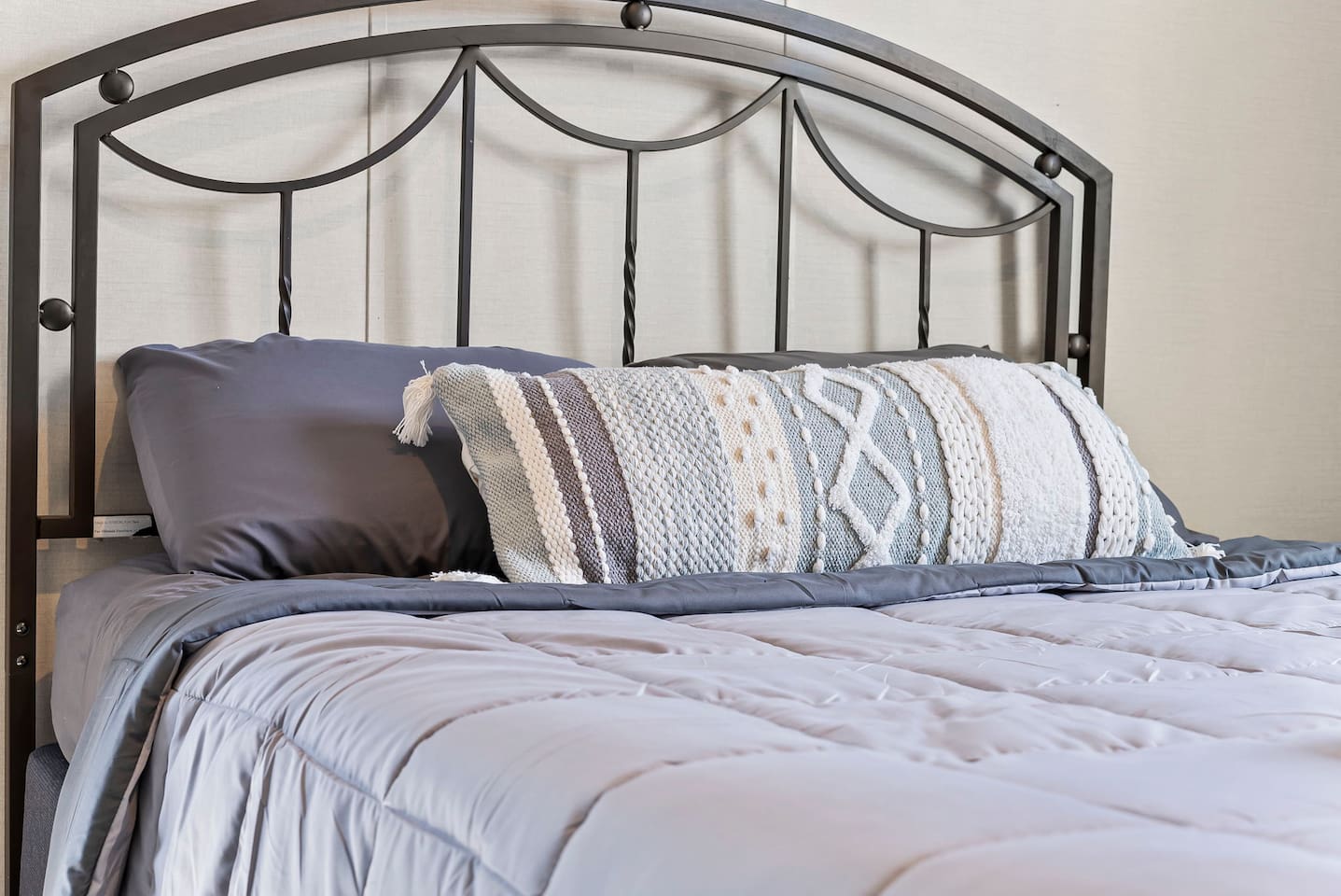 Plush bed with fresh linens and accent pillows—designed for comfort and relaxation.