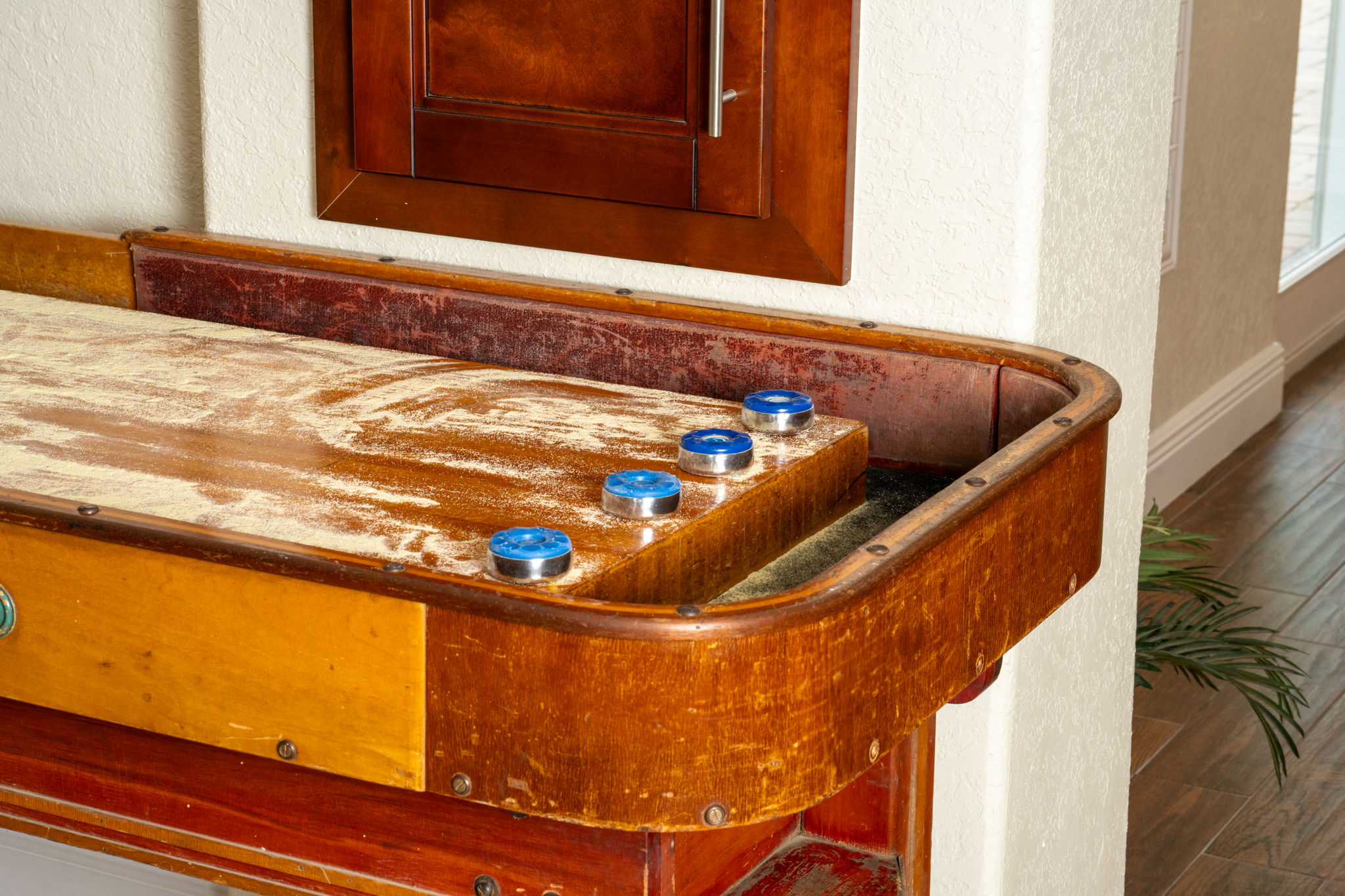 A classic shuffleboard table adds charm and fun to this bright, open area with tile floors and crown molding.