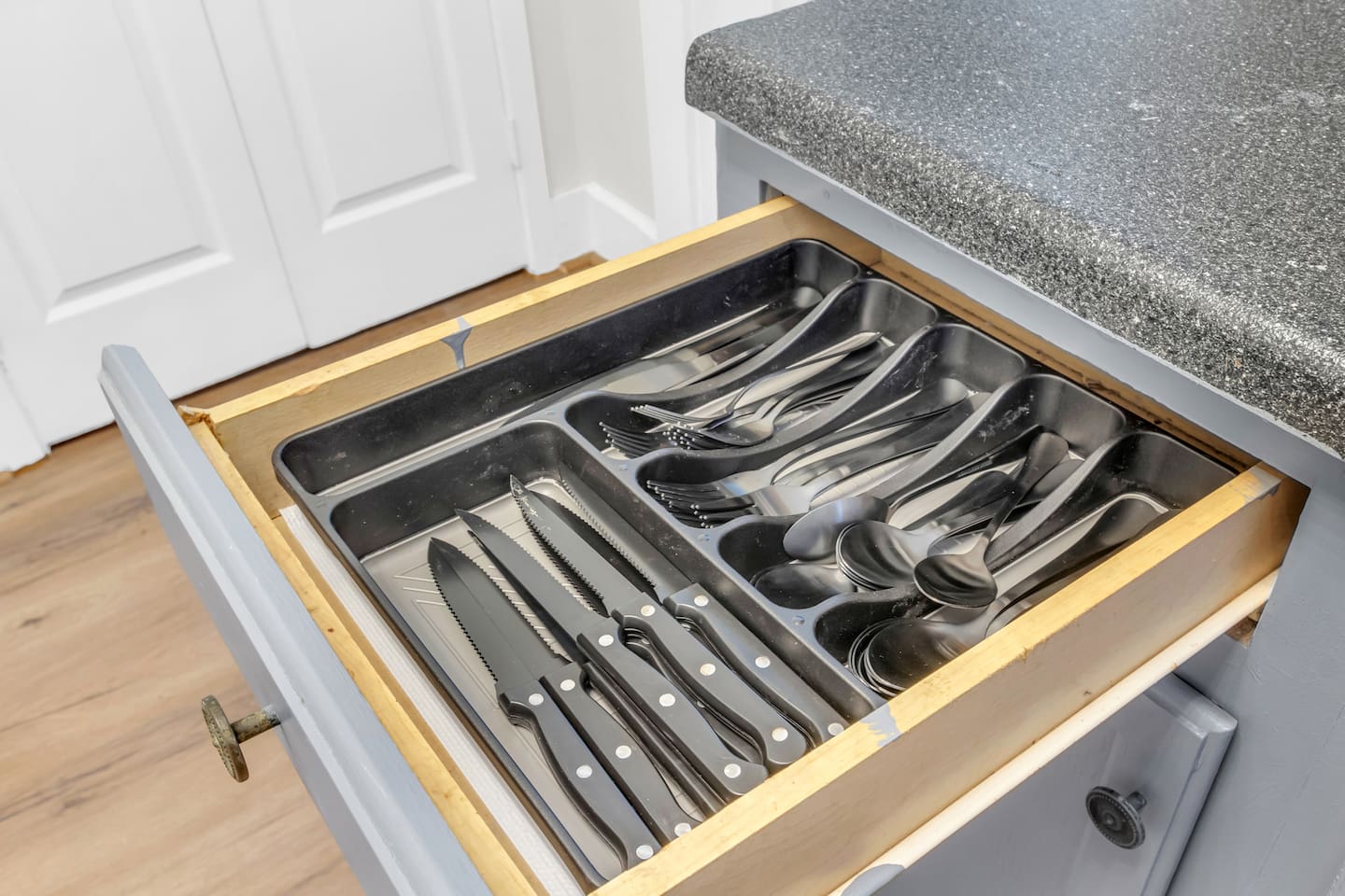 Kitchen drawers fully stocked with utensils for home cooking.