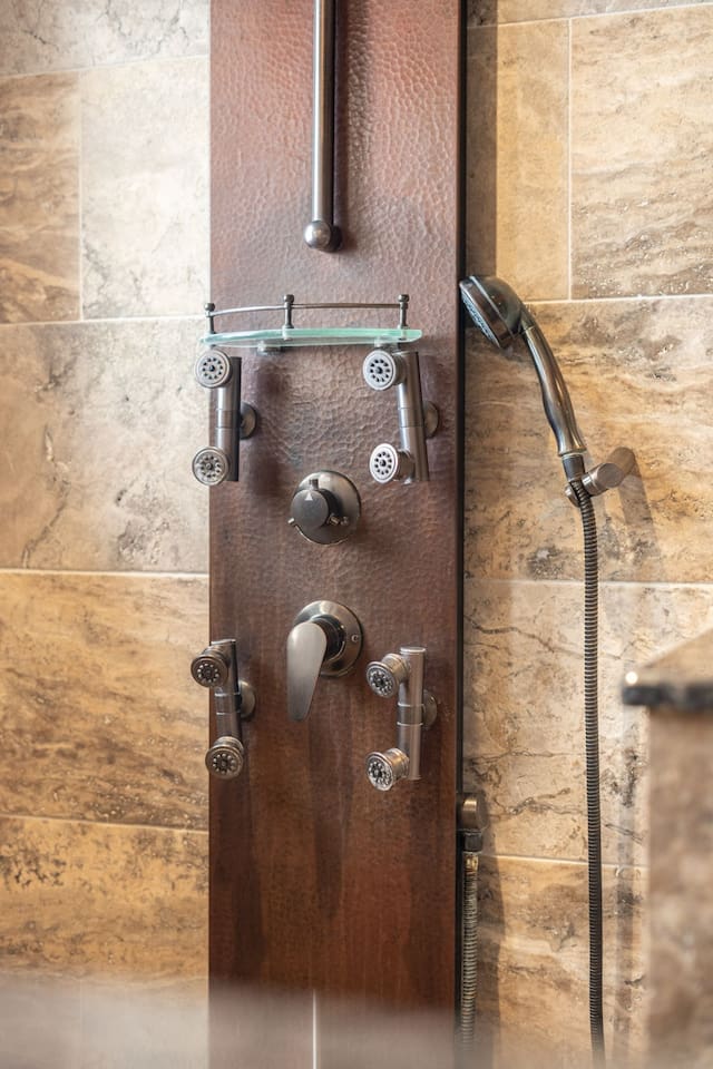 The custom copper shower panel puts a spa at your fingertips — multiple body jets, a handheld wand, and precise controls let you dial in the perfect shower every time.