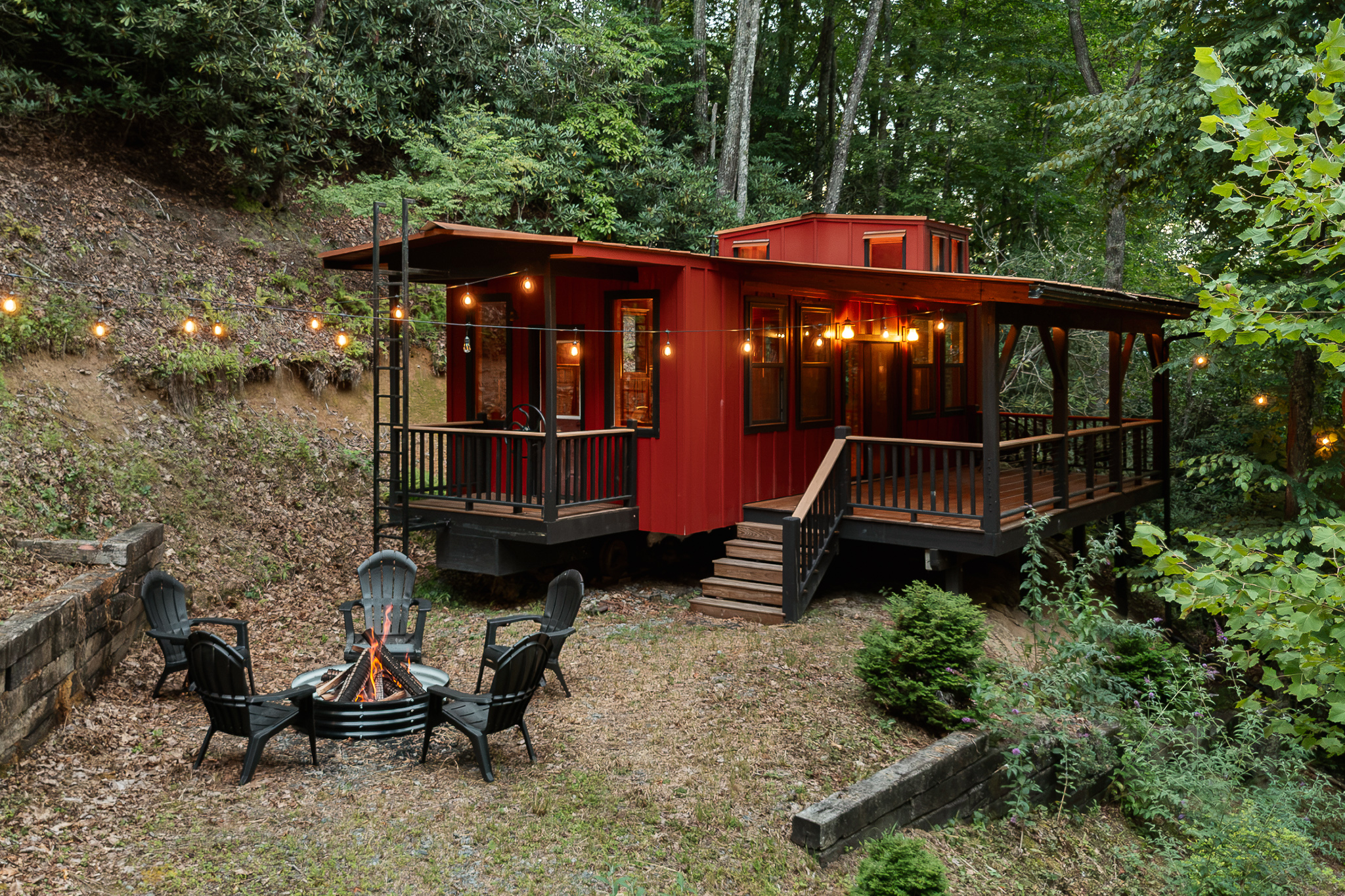 {Hidden Caboose} Follow the private forest trail to our tucked-away red caboose—a one-of-a-kind Pisgah Forest hideaway complete with its own fireside gathering spot.