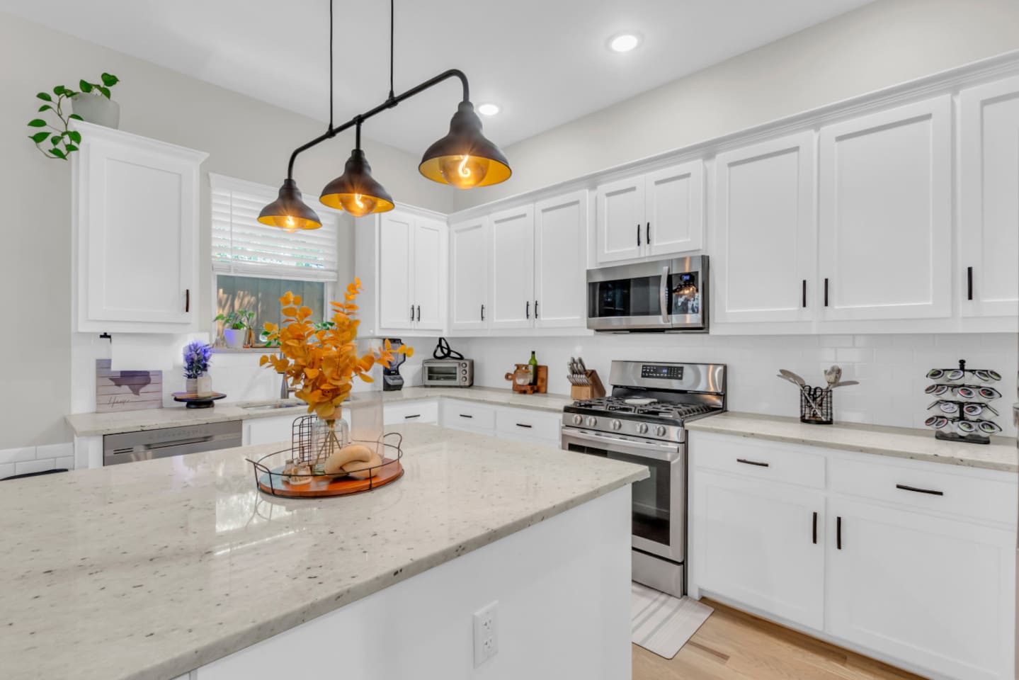 Kitchen view with stainless steel appliances such as a toaster oven, coffee maker, blender, microwave, and oven and oversized island.