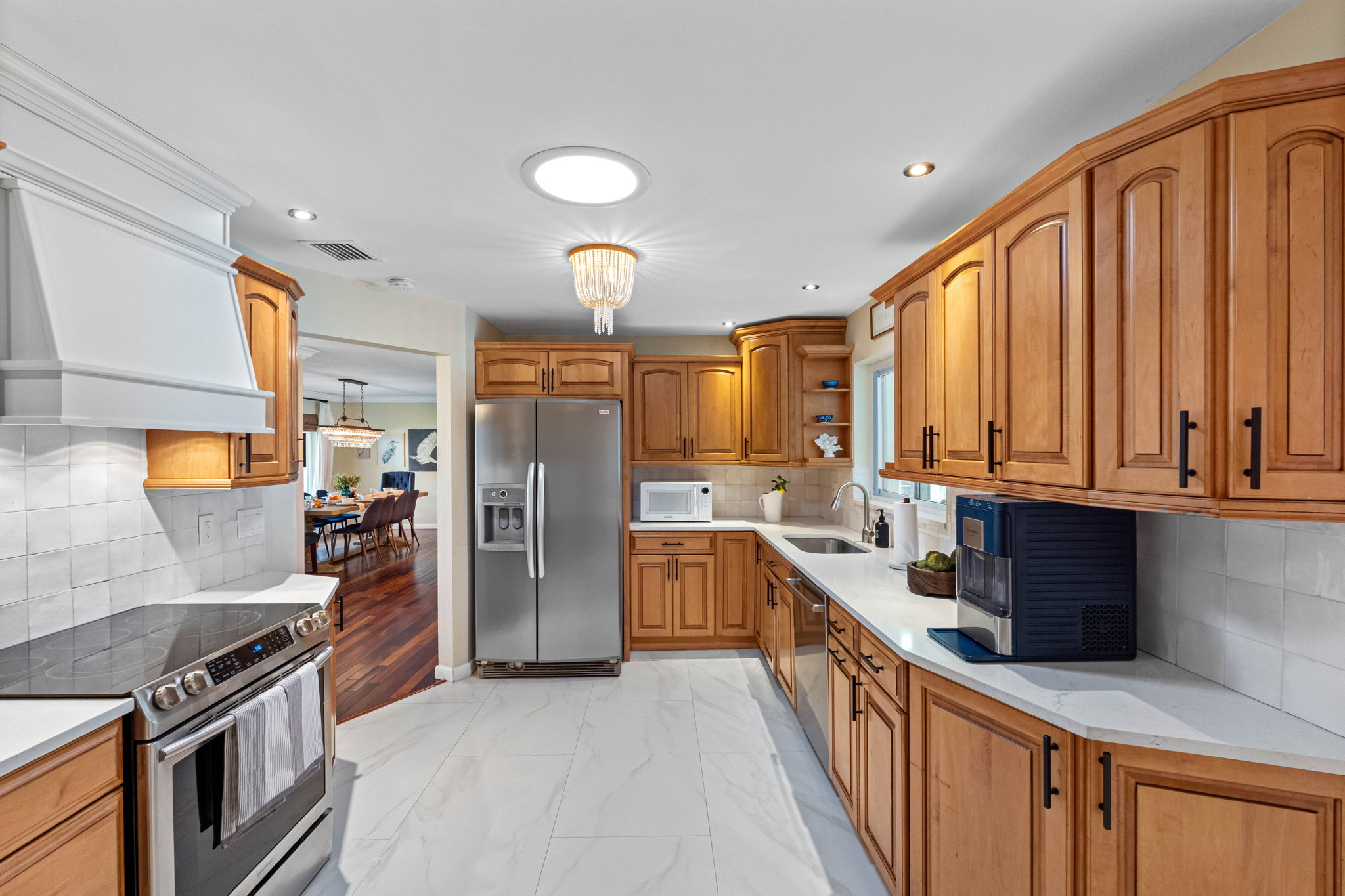 Stainless steel appliances pair beautifully with the natural wood cabinetry in this spacious and inviting kitchen.