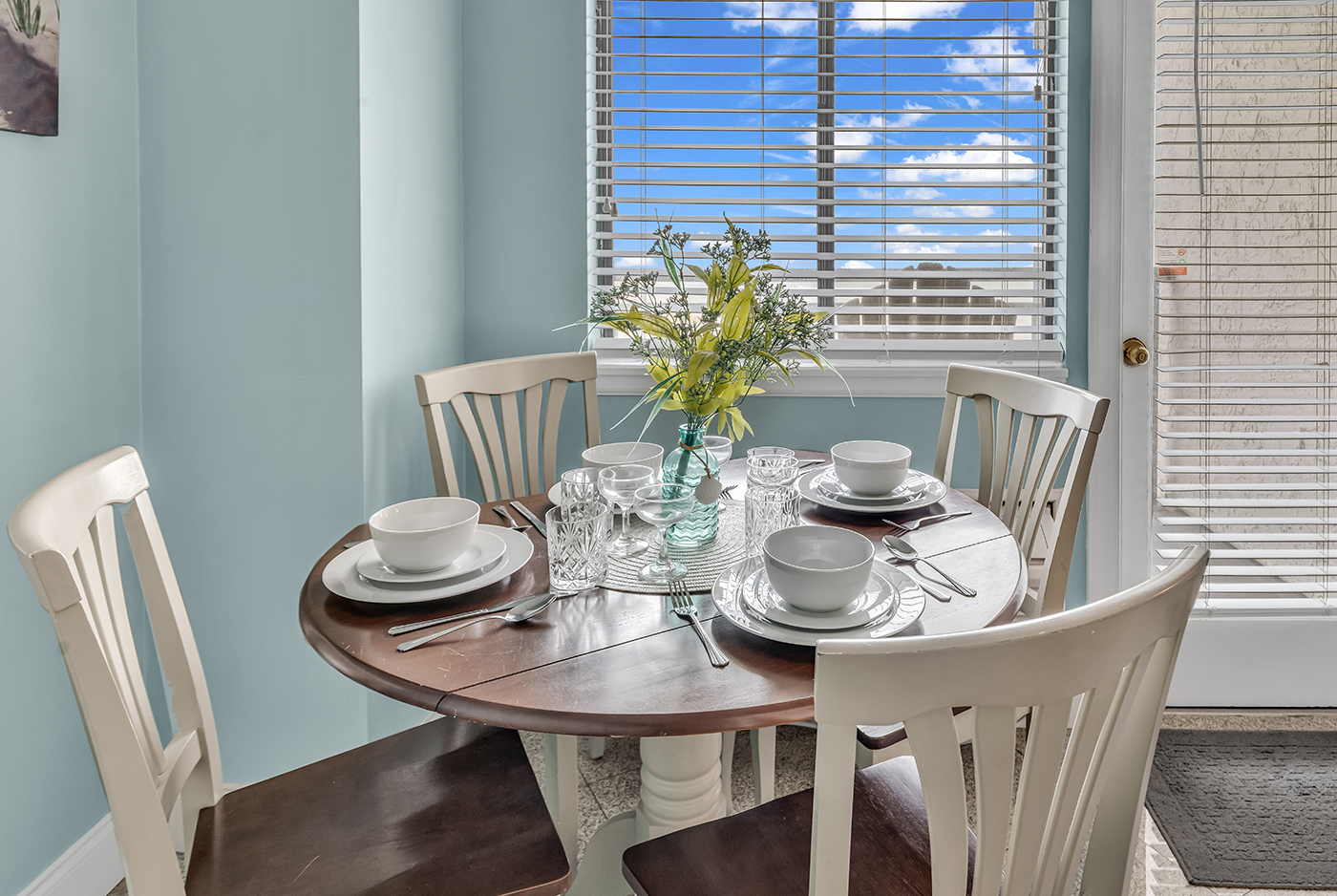 Round dining table set for 4 — perfect for meals with a view of the ocean outside