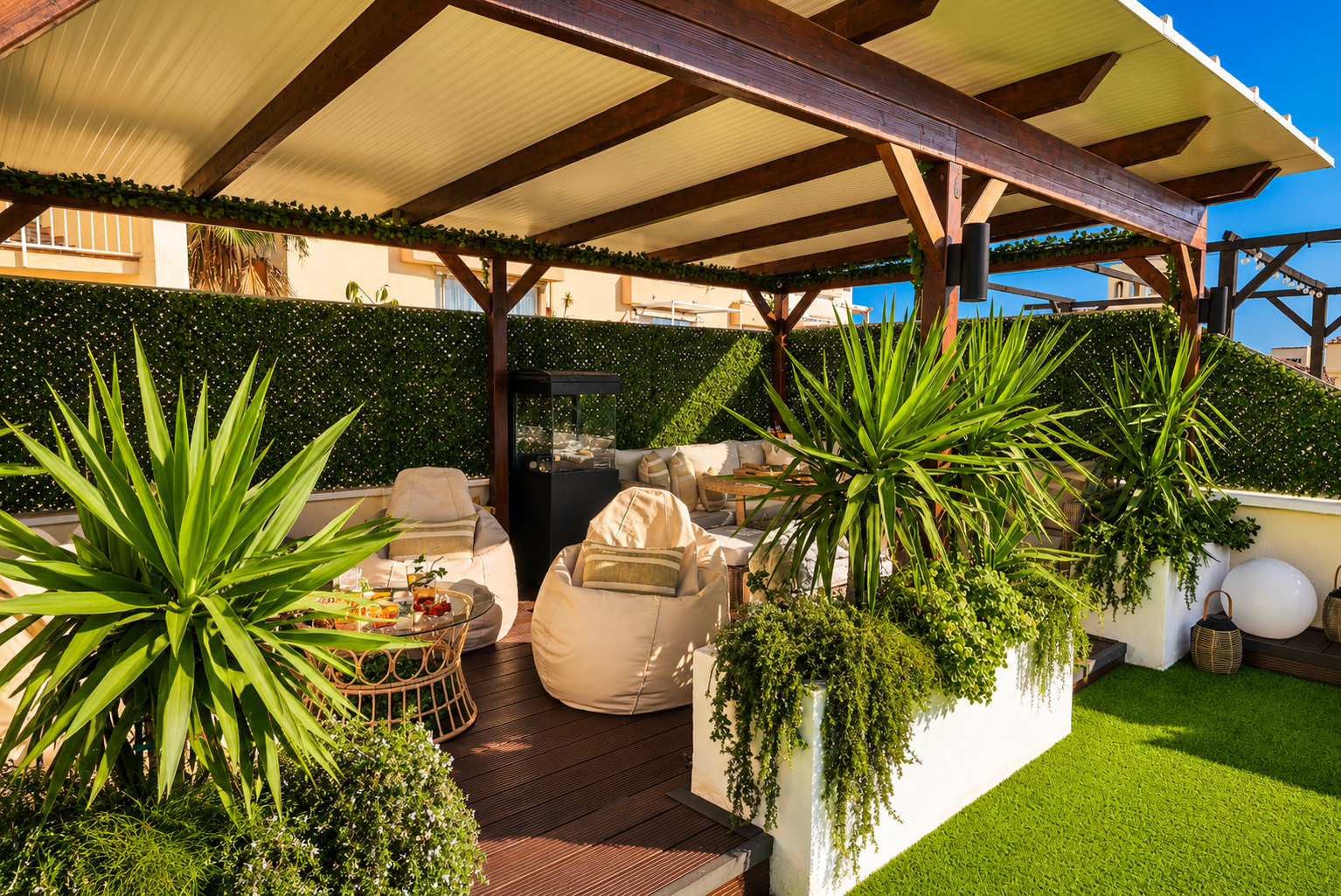 Relax beneath the covered pergola with cozy seating, fireplace, and dining area. Perfect for long evenings, romantic dinners, or movie nights on the outdoor TV under soft ambient lights.