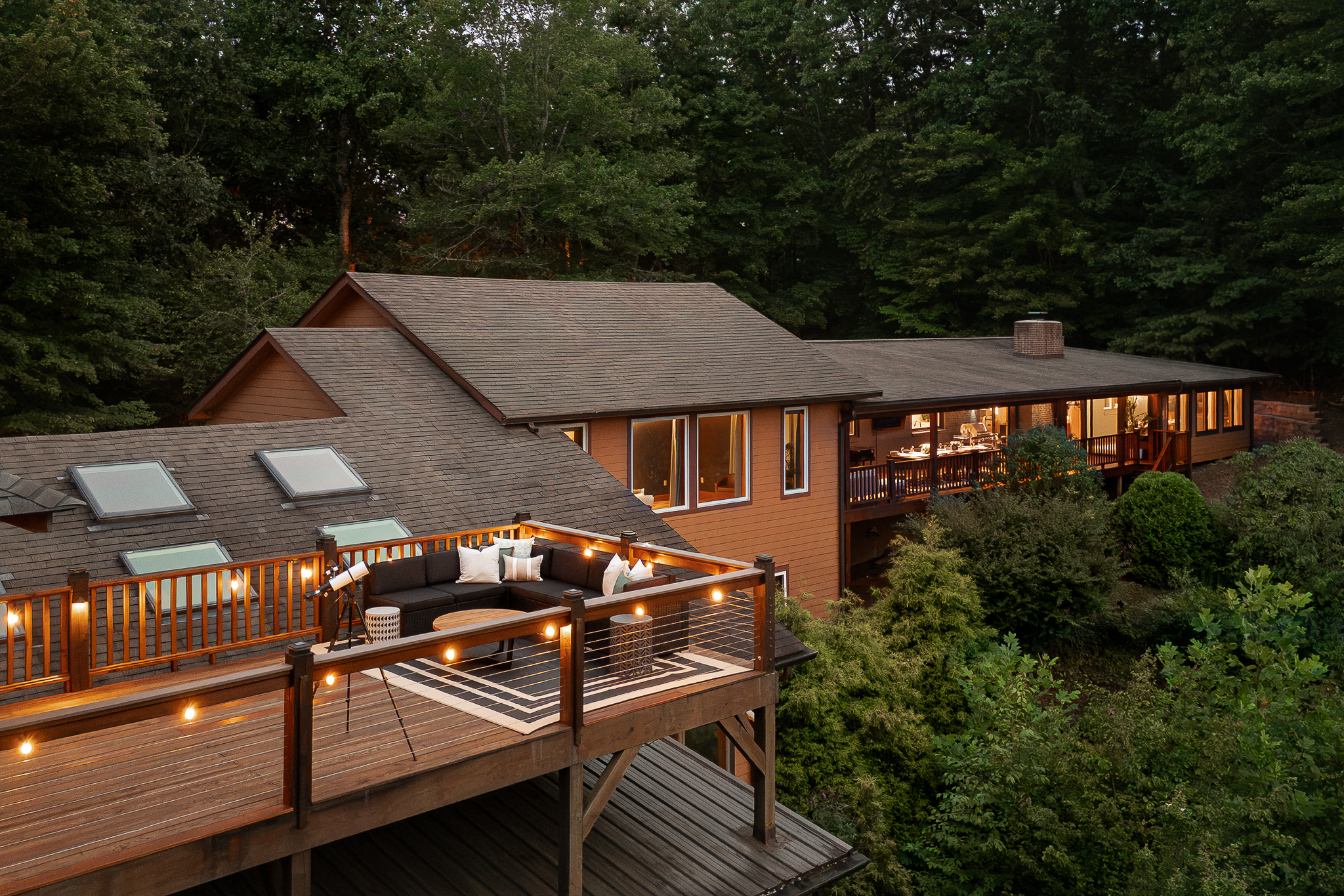{Private Mountain Resort} Multiple decks cascade along the mountainside, creating plenty of outdoor spaces to gather, dine, lounge, and take in the forest setting.
