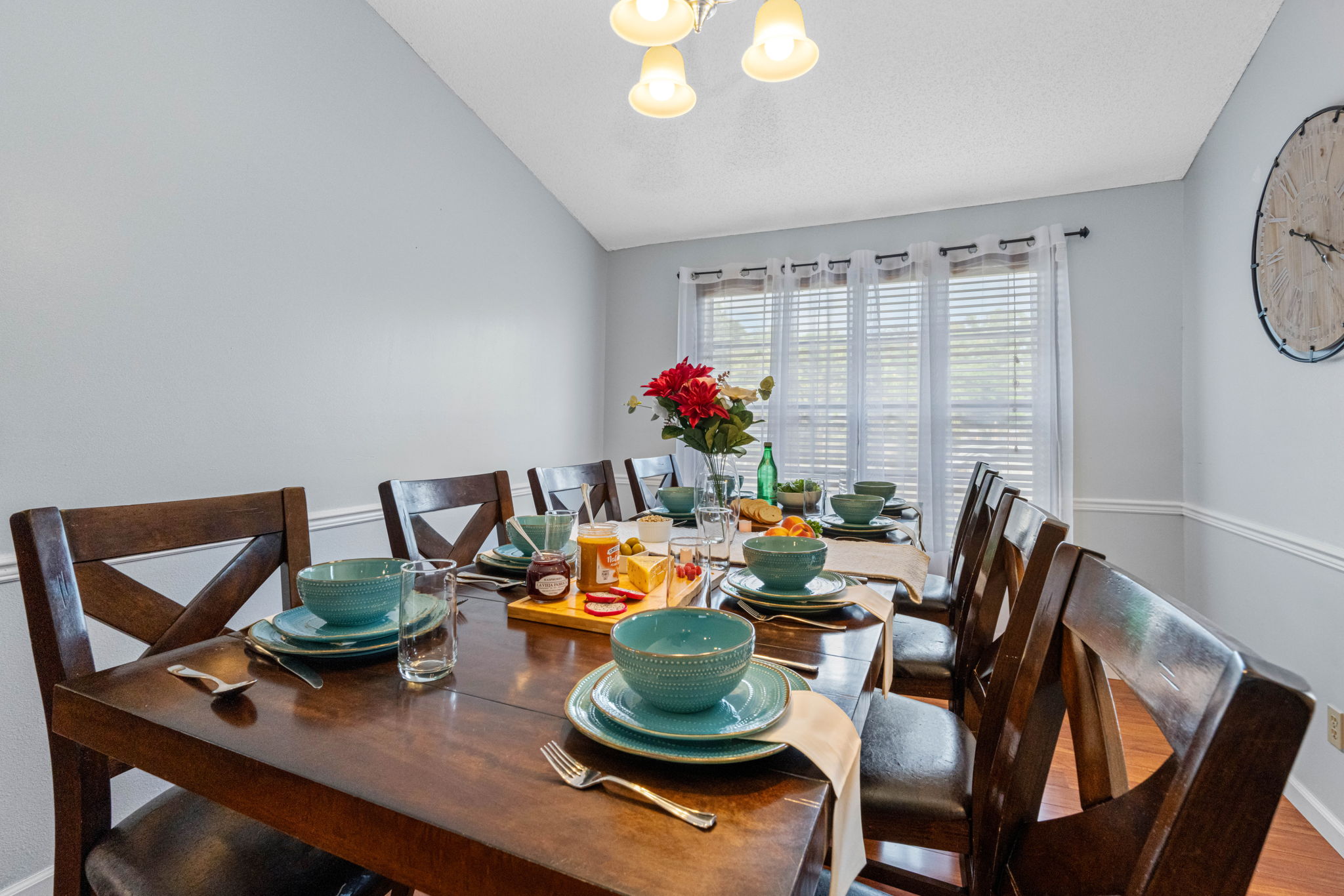 Enjoy meals together at this thoughtfully arranged dining table, complete with elegant settings and a centerpiece that adds a pop of color.