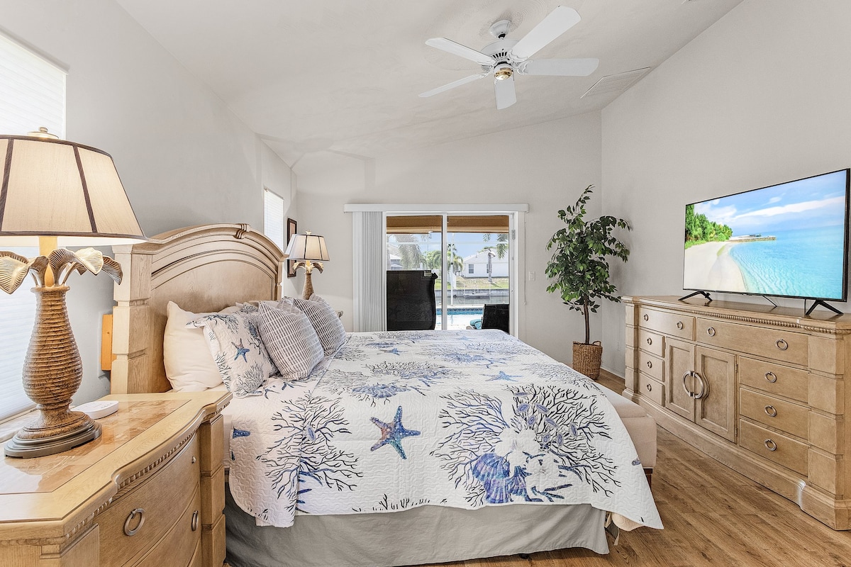 Elegant primary bedroom with king bed and a large flat-screen TV for relaxing evenings