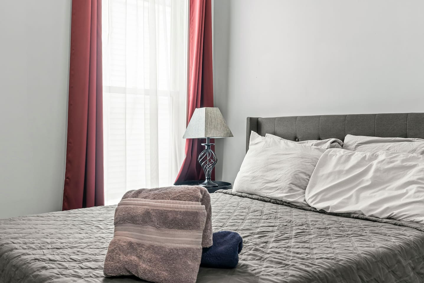 Close-up of the full-size bed with fresh linens and bedside lamp, creating a cozy sleep space.