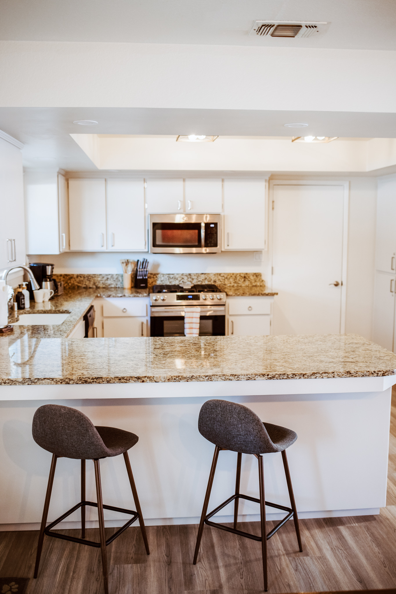 Enjoy a morning espresso at the sleek granite breakfast bar in this bright, modern kitchen.