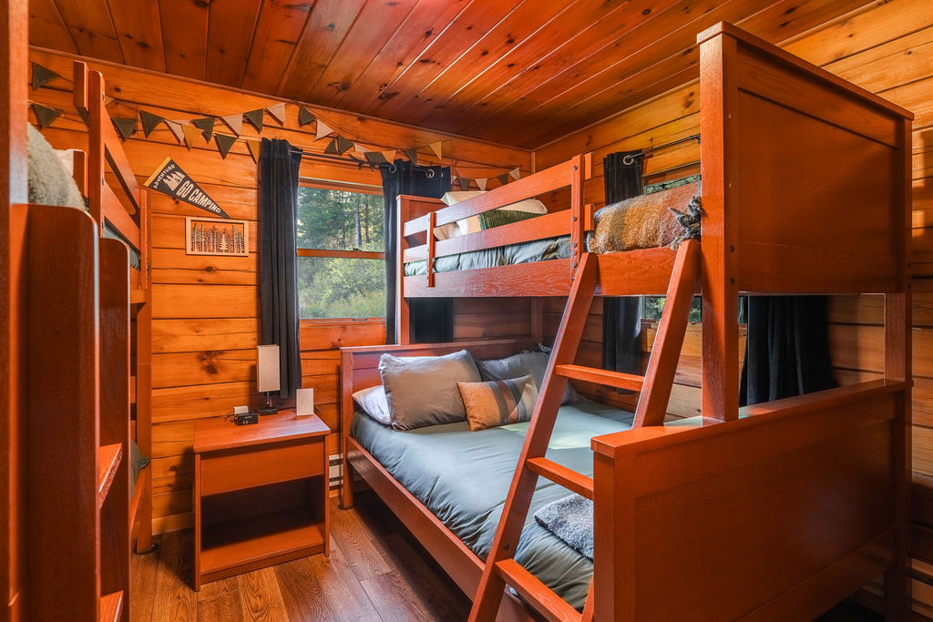 The guest room features two bunk beds: one twin-over-twin and one twin-over-full, offering cozy sleeping space for up to five.