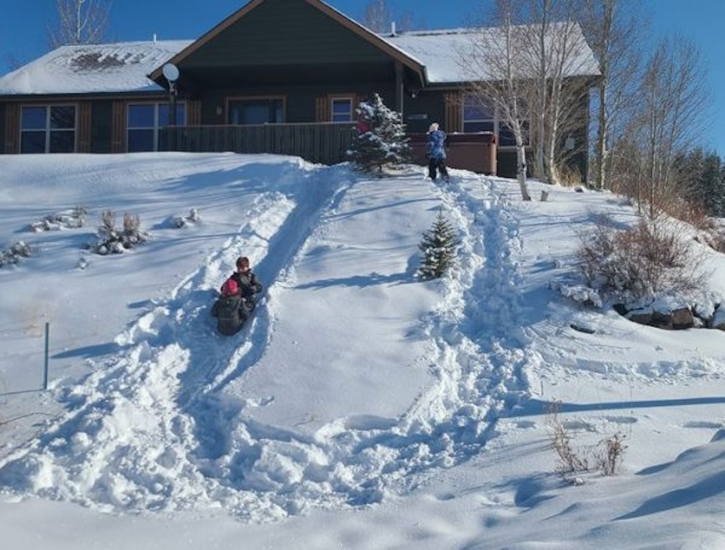 Kids sledding off the front of our home