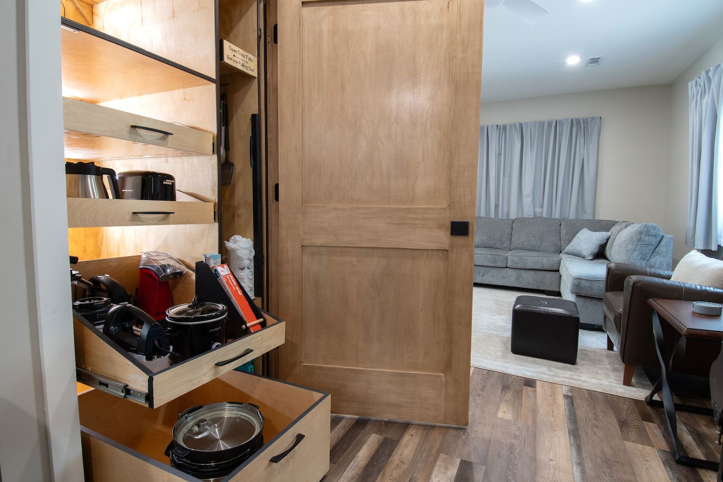 Spacious pantry with pullouts. Kitchen items include mini crock pot, Instant Pot, hand mixer, blender, waffle maker, and air popper.